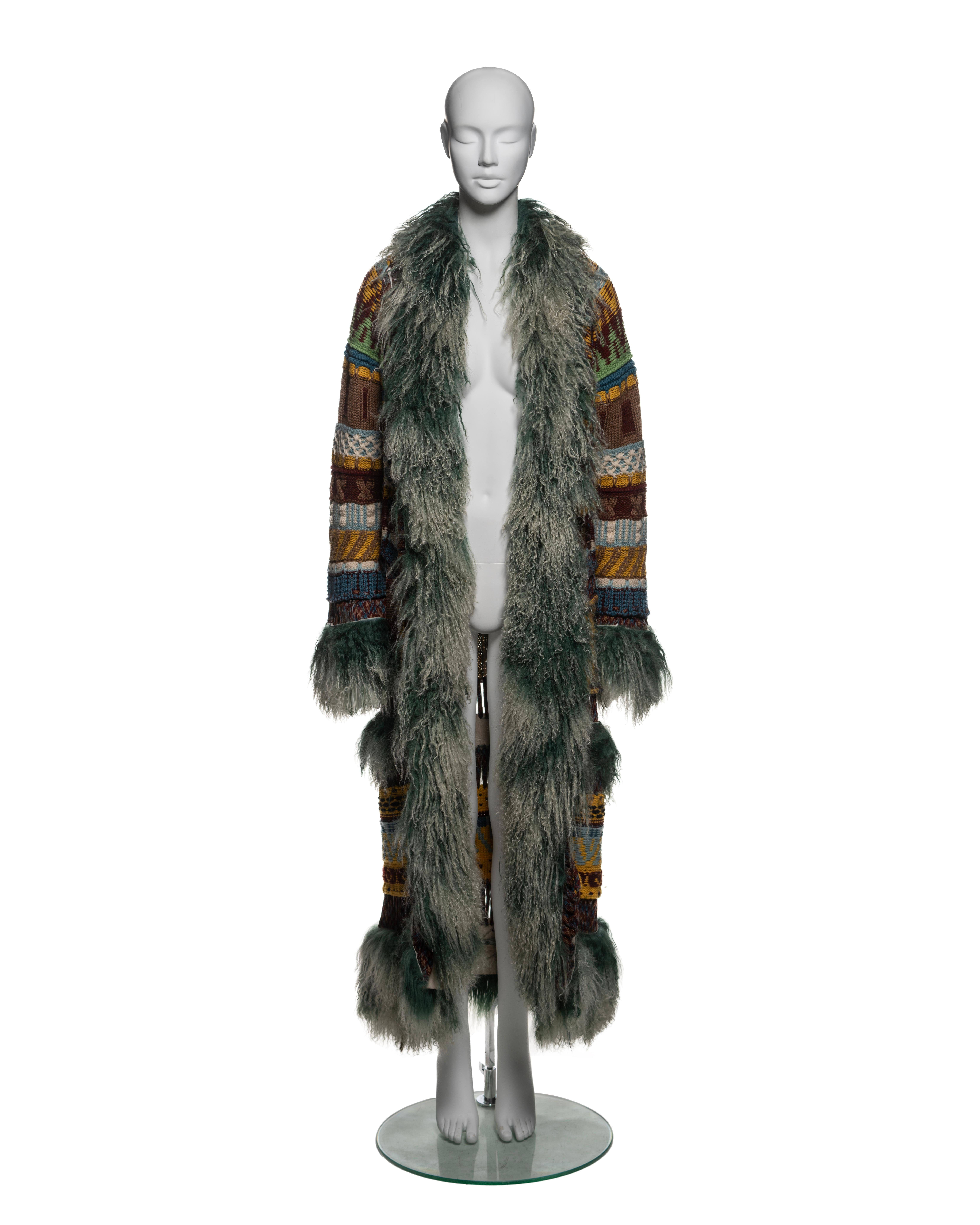 Questo cappotto Jean Paul Gaultier della collezione Autunno-Inverno 2004 è realizzato con un patchwork di pannelli di lana vergine in un'ampia gamma di tonalità della terra, tra cui marrone, verde, blu e senape, con una varietà di intricati motivi a