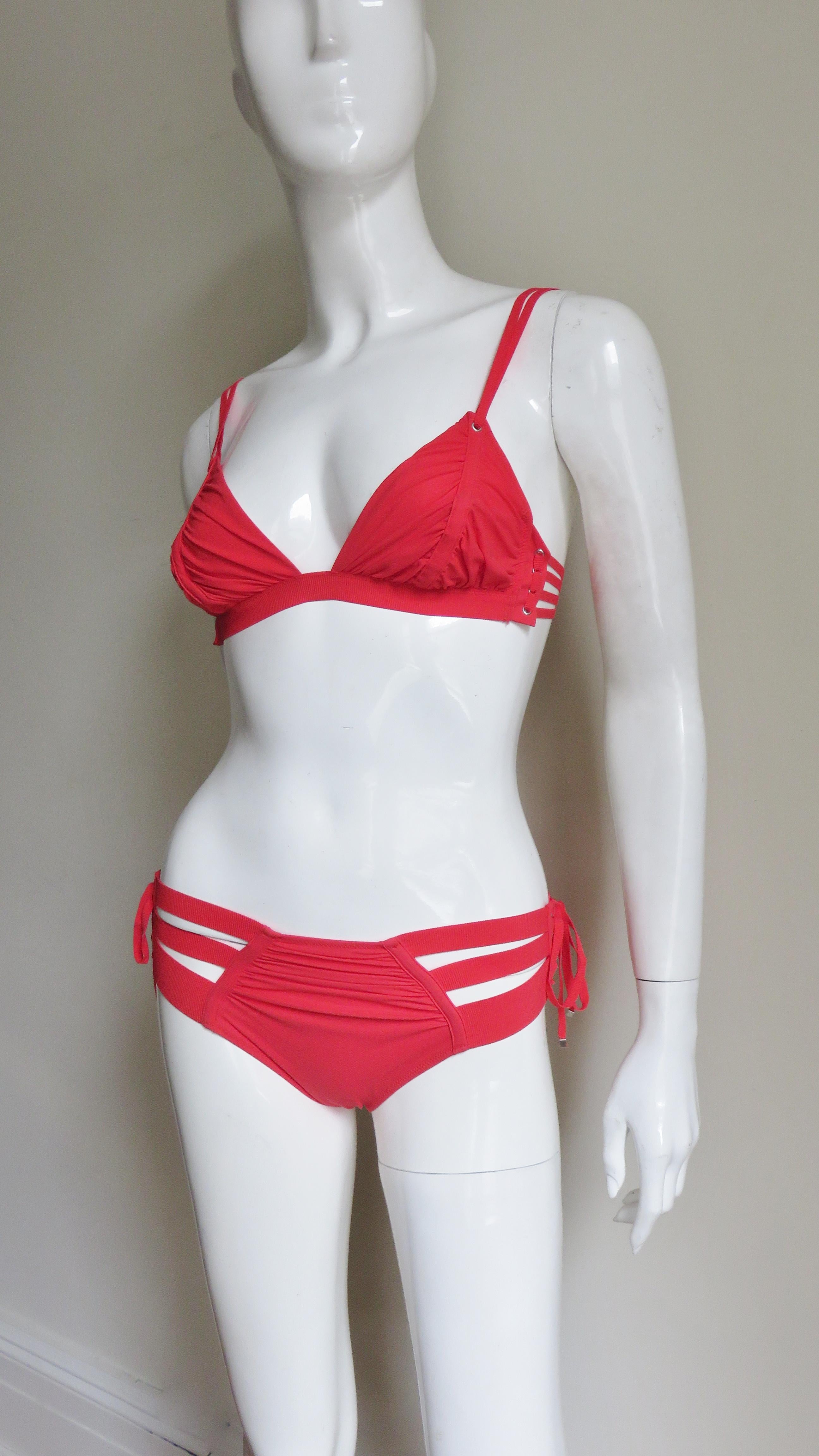 A fabulous red 2 piece bikini swimsuit from Jean Paul Gaultier for La Perla.  The top has double shoulder straps, 3 side straps and closes with a matching back clasp.  The bottoms have center front and back ruching with three stretch bands on the