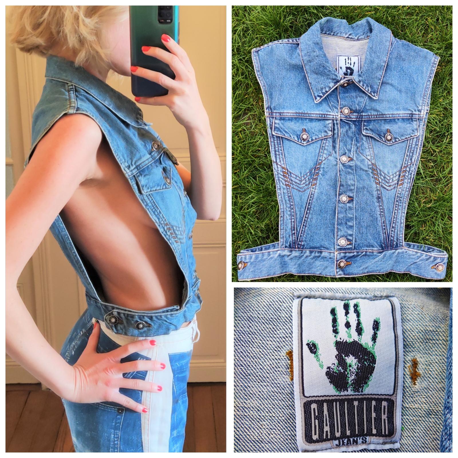 Features:
- 100% Authentic JEAN PAUL GAULTIER.
- Denim vest with open sided feature.
- Adjustable waist band and 2 breast pockets.
- Button down closure.
- Metal GAULTIER JEAN'S PARIS enamel plaque at the back.
- GAULTIER JEAN`S buttons.
-