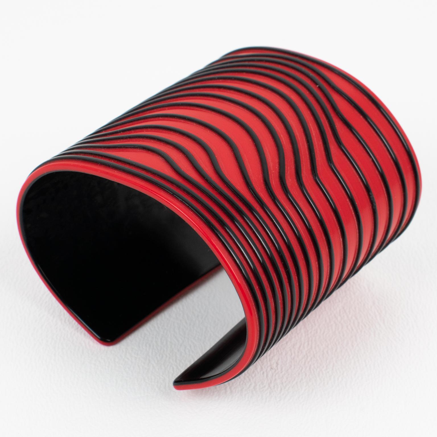 This stunning Jean Paul Gaultier Paris resin cuff bracelet features a kinetic striped design with carved black lines pattern over a bright red background. The design reminds me of the iconic nautical sweater that Gaultier became famous for. The