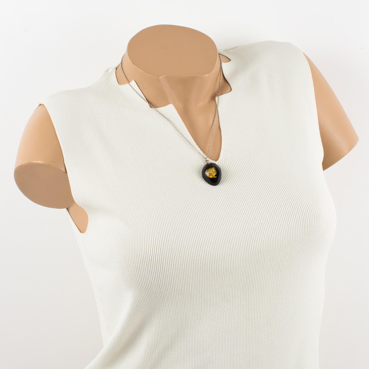 Jean Paul Gaultier Paris a conçu ce superbe collier à pendentif dans les années 1990 pour sa collection Steampunk. Le modèle se compose d'une chaîne en métal argenté avec un fermoir de type homard, ornée d'un pendentif en forme de larme multicouche