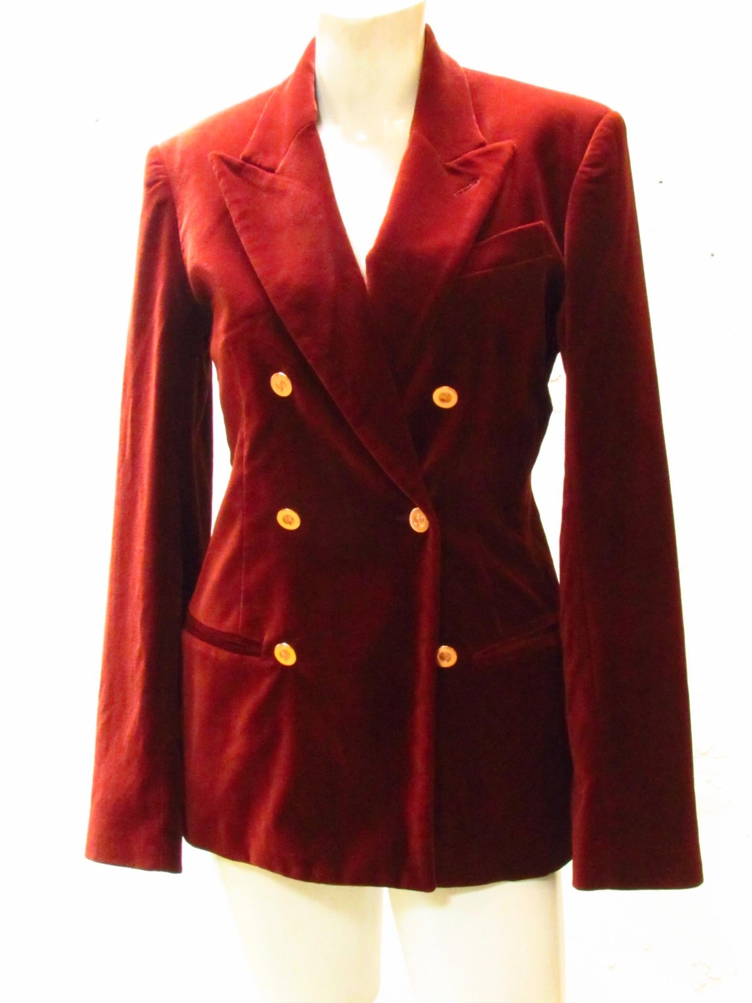 Double breasted cotton velvet jacket from Jean Paul Gaultier in a rich rust color. Metal buttons  showcase the JPG logo. The lining is replete with fanciful versions of the logo.