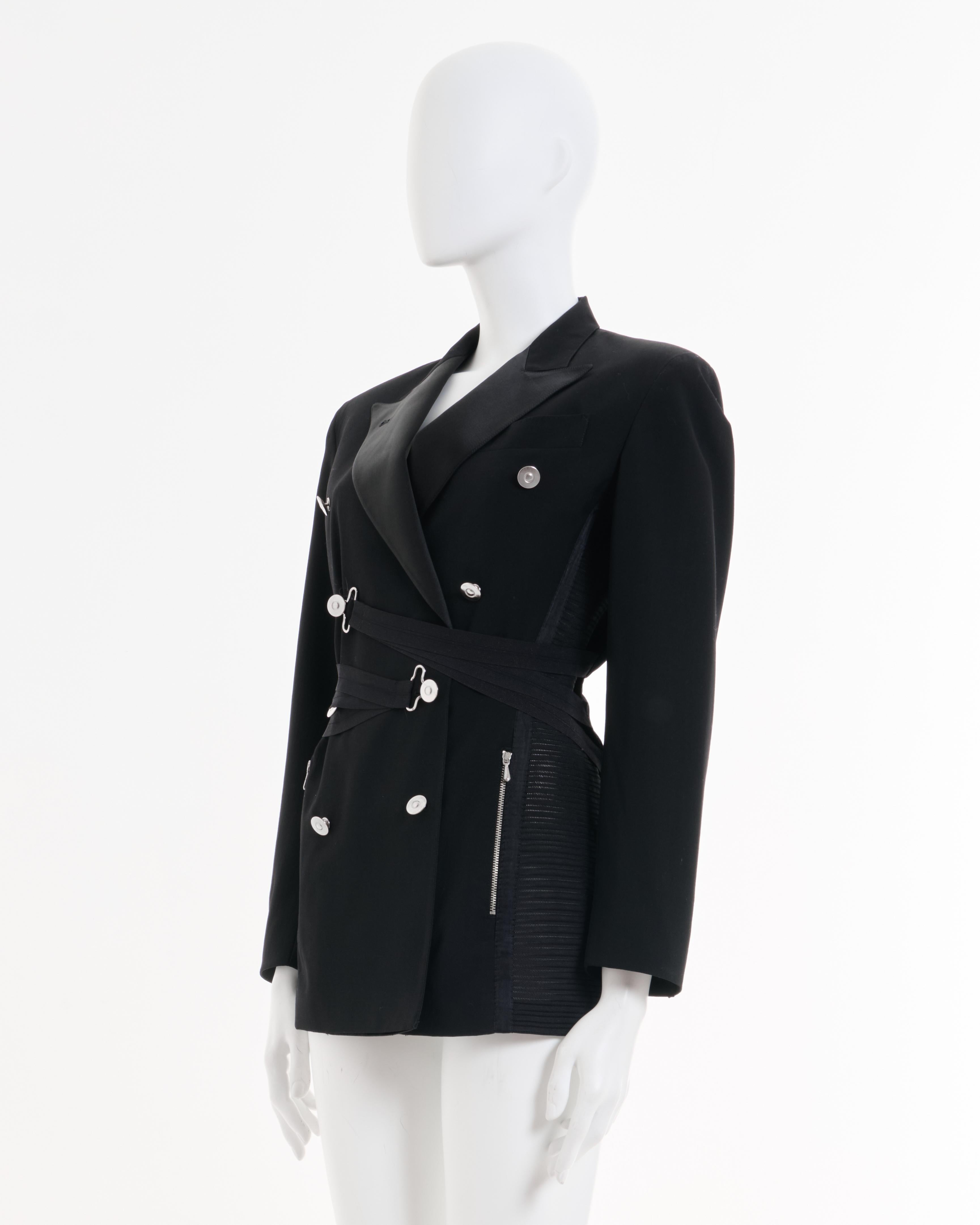 - Archival Jean Paul Gaultier black bondage blazer 
- Spring - Summer 1987
- Sold by Skof.Archive 
- Figure-hugging calf-length jacket
- Double-breasted blazer jacket
- Metal button featuring group of three elastic band who can be fixed on buttons
