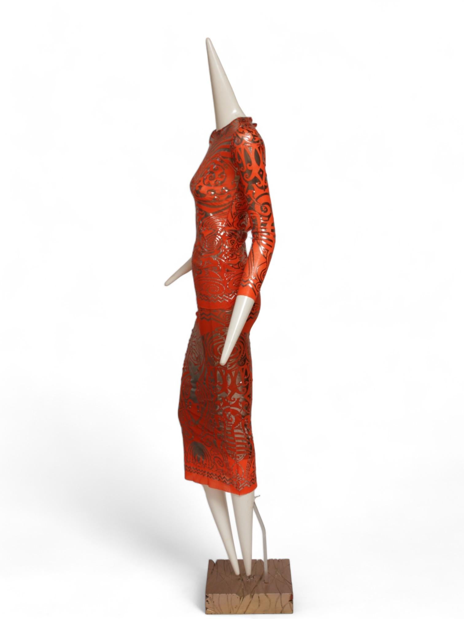 Dall'iconica Collection'S/S 1996 di Jean Paul Gaultier Cyber arriva questo accattivante ensemble di tatuaggi tribali arancioni e argento. Questo ensemble in rete è composto da una camicia a maniche lunghe e da una maxi gonna.