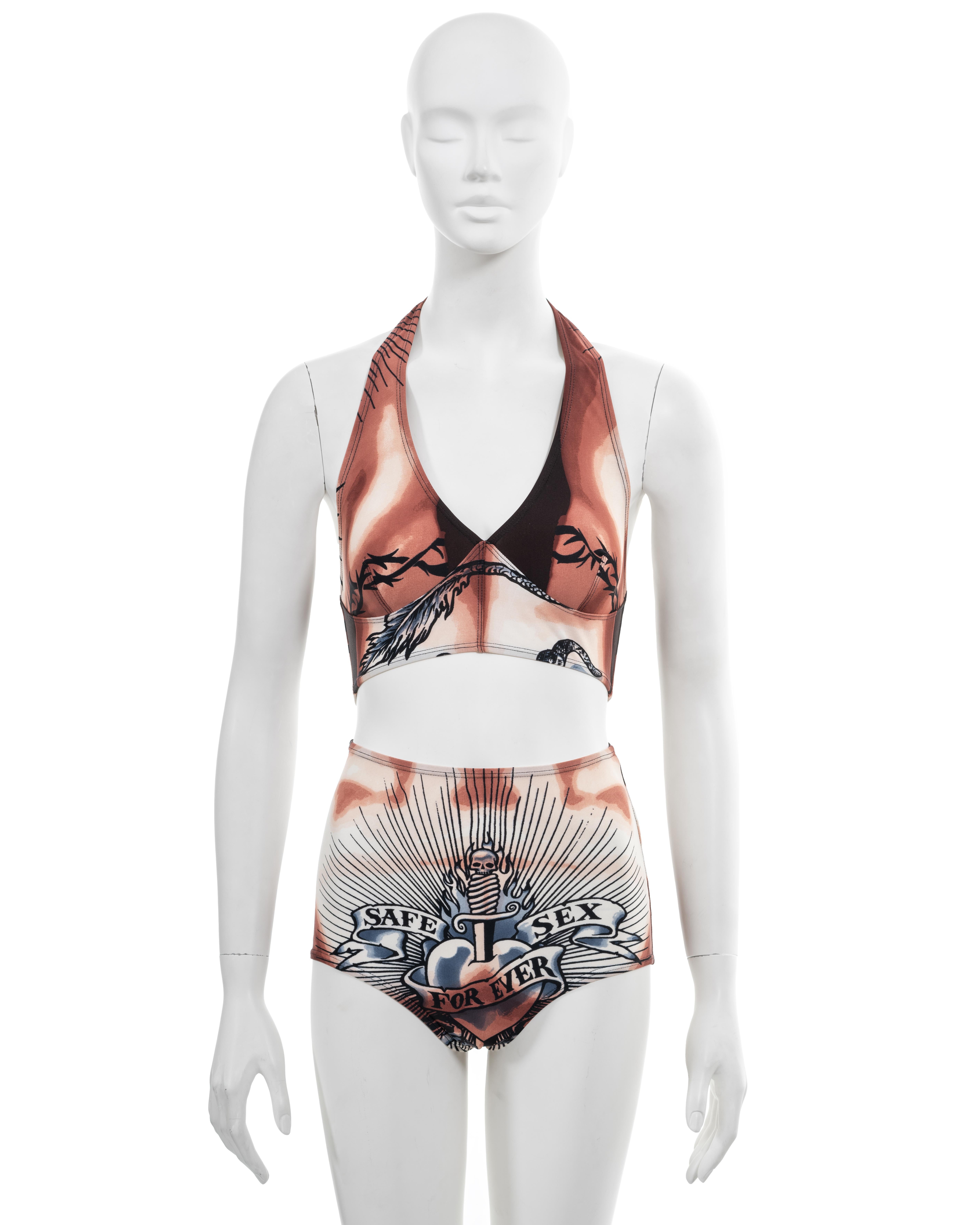 ▪ Archival Jean Paul Gaultier 2-piece set 
▪ Spring-Summer 1996
▪ Sold by One of a Kind Archive
▪ Iconic 'Safe Sex Forever' tattoo-print 
▪ Halter-neck crop top 
▪ High-rise panties 
▪ 78% Nylon, 22% Spandex 
▪ Size Medium
▪ Made in Italy

The