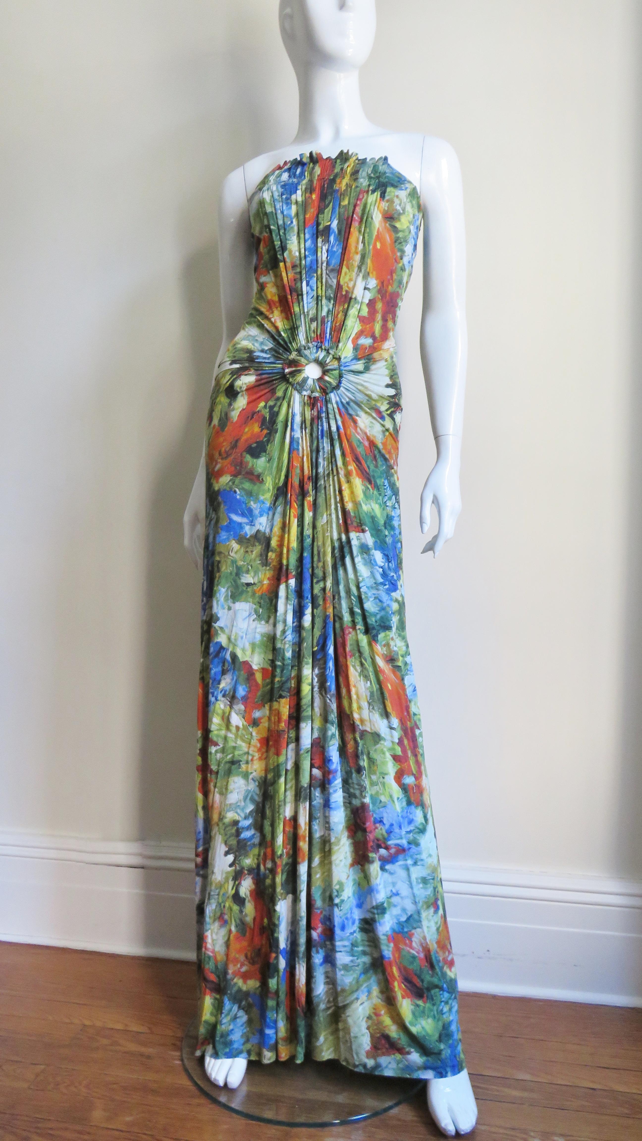 A beautiful silk jersey maxi dress from Jean Paul Gaultier in a blue, green, yellow and red abstract print.  It is strapless with ruching extending from the strapless bodice top through the hips all emanating from a circle cutout below the waist-