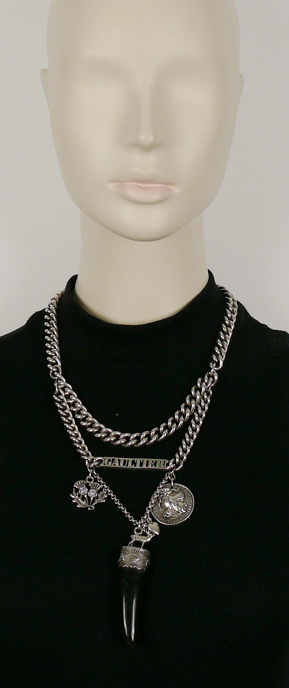 JEAN PAUL GAULTIER silver toned curb chain necklace featuring GAULTIER ID tag and charms  : faux horn tooth claw, jewelled thistles, heart, acorn, Roman centurion coin.

Lobster clasp closure.

Embossed JEAN PAUL GAULTIER.

Indicative measurements :