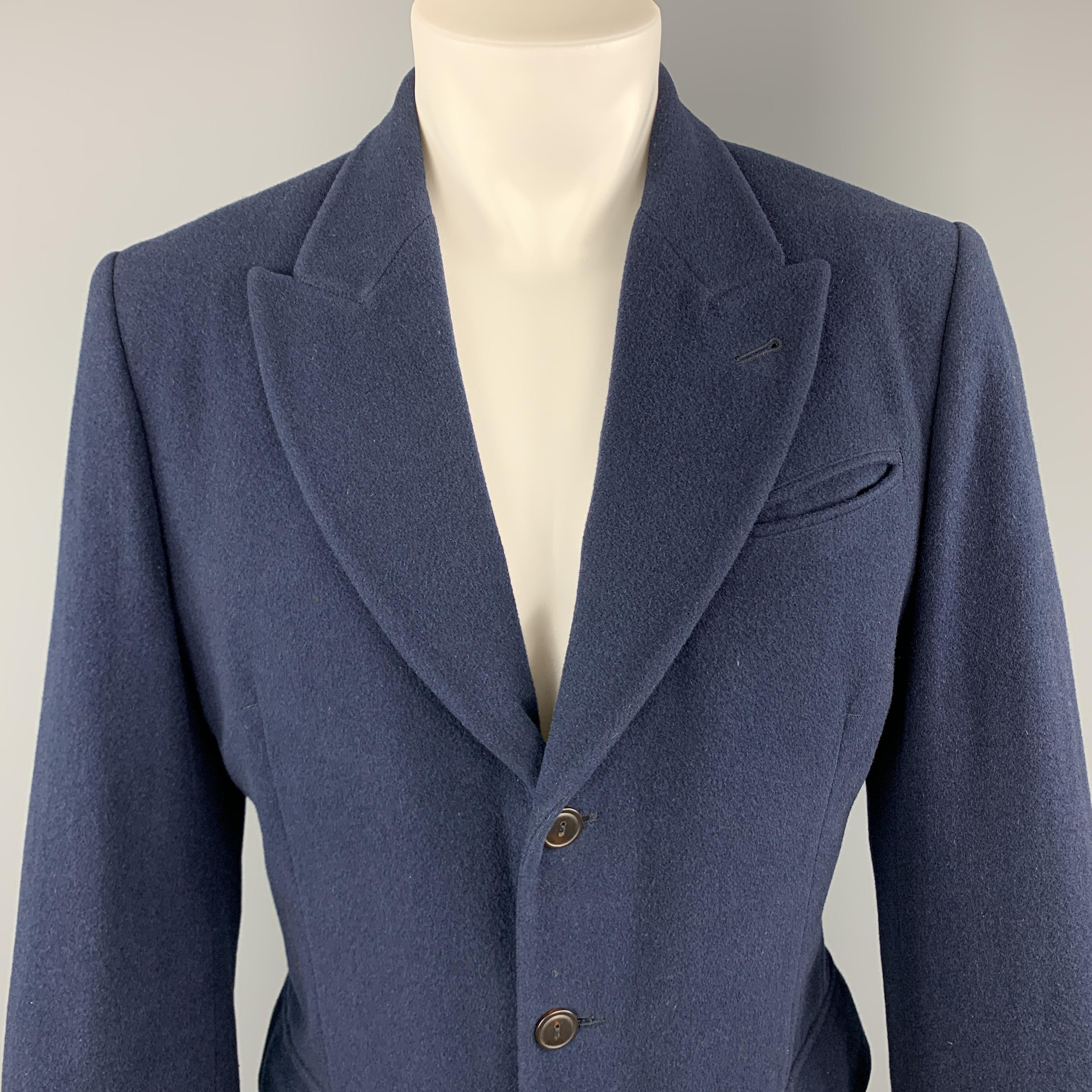 Vintage JEAN PAUL GAULTIER sport coat comes in heavy muted navy blue lana wool with a peak lapel, single breasted three button front, patch flap pockets, functional button cuffs, back belt detail, and striped liner. Made in Italy. 

Good Pre-Owned