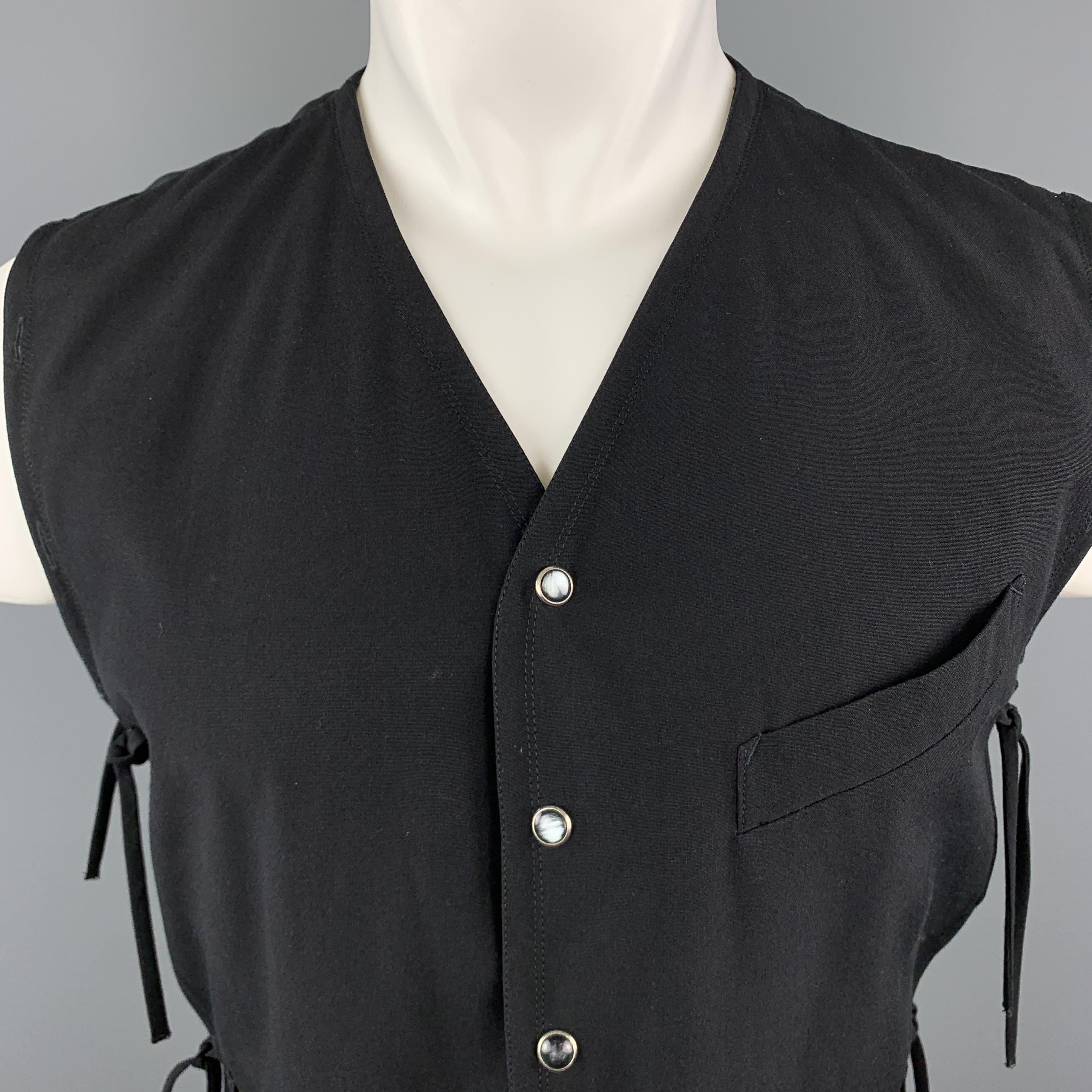 Vintage JEAN PAUL GAULTIER HOMME vest comes in black wool with a V neck, pearl snap up front, cropped hem, and button hole trim with tied sides. Missing middle ties. Otherwise excellent condition. As-is. Made in Italy.

Very Good Pre-Owned