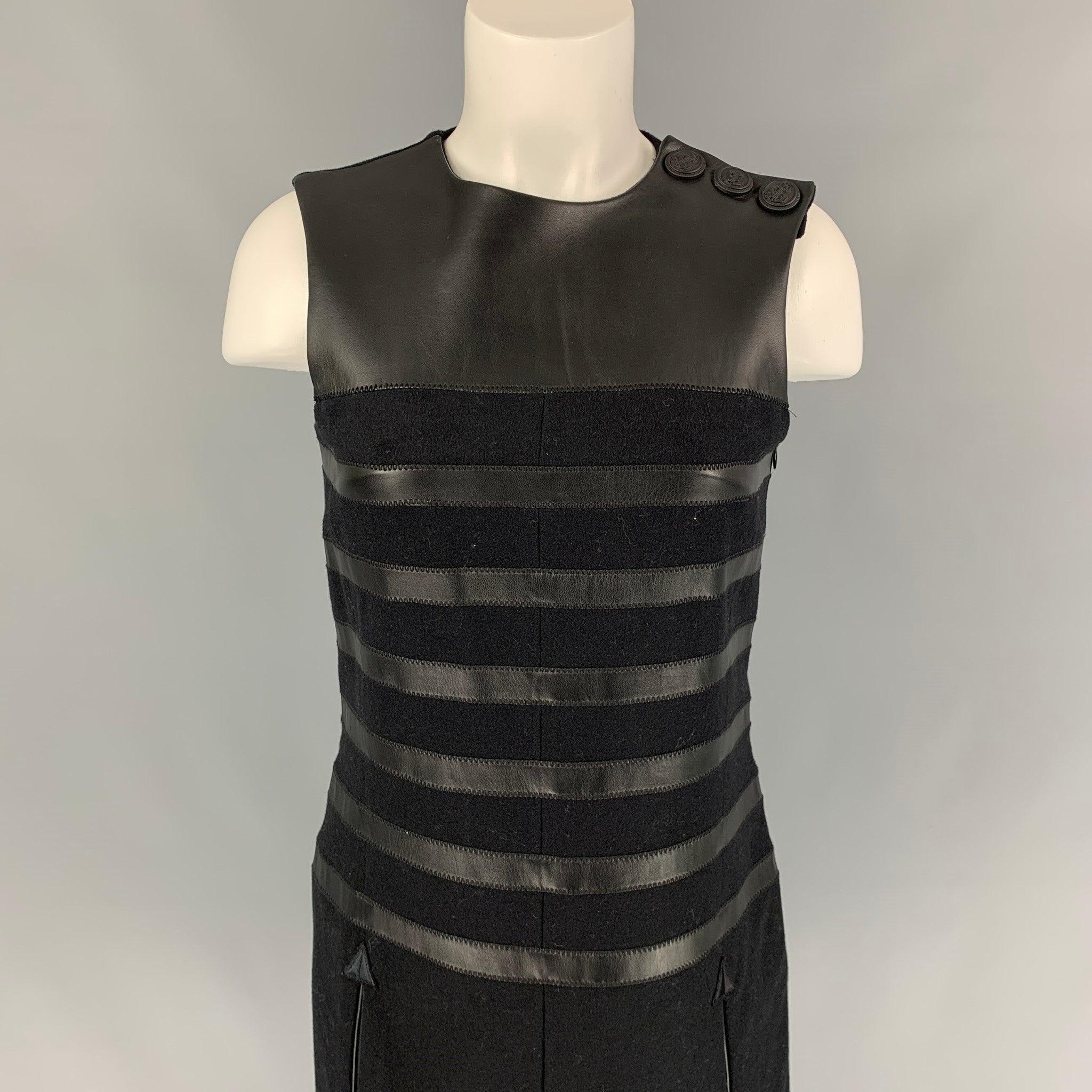 La robe JEAN PAUL GAULTIER se compose de laine mélangée noire et de détails en cuir. Elle présente un style décontracté, des poches fendues, une fente sur le devant, une fente dans le dos, trois boutons sur l'épaule et une fermeture zippée sur le