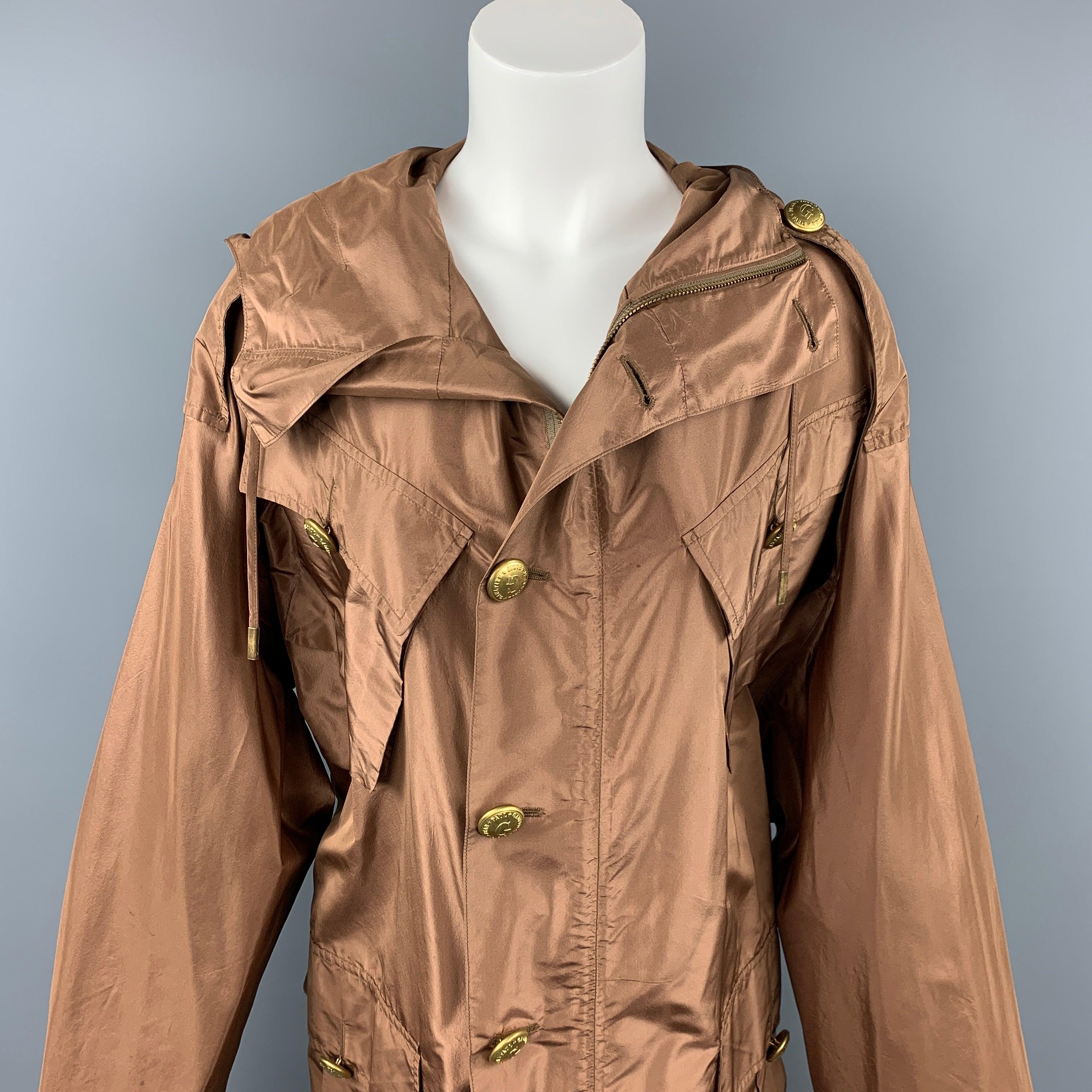 JEAN PAUL GAULTIER jacket comes in a copper silk featuring a hooded style, elastic waistband, oversized fit, epaulettes, patch pockets, and a brass button closure. Missing two buttons. As-Is. Made in Italy.
Good
Pre-Owned Condition. 

Marked:   I 40