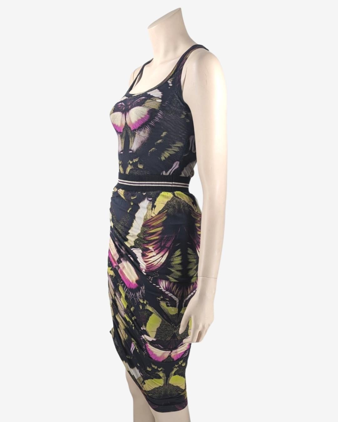 Di Jean Paul Gaultier della linea Soleil. Set di due pezzi con stampa di farfalle. 

Circa anni '90.

- Canotta
. Tessuto a rete 
. completamente foderato con una rete nera
. Nessuna trasparenza
. Gonna midi
. Gonna asimmetrica con arricciatura