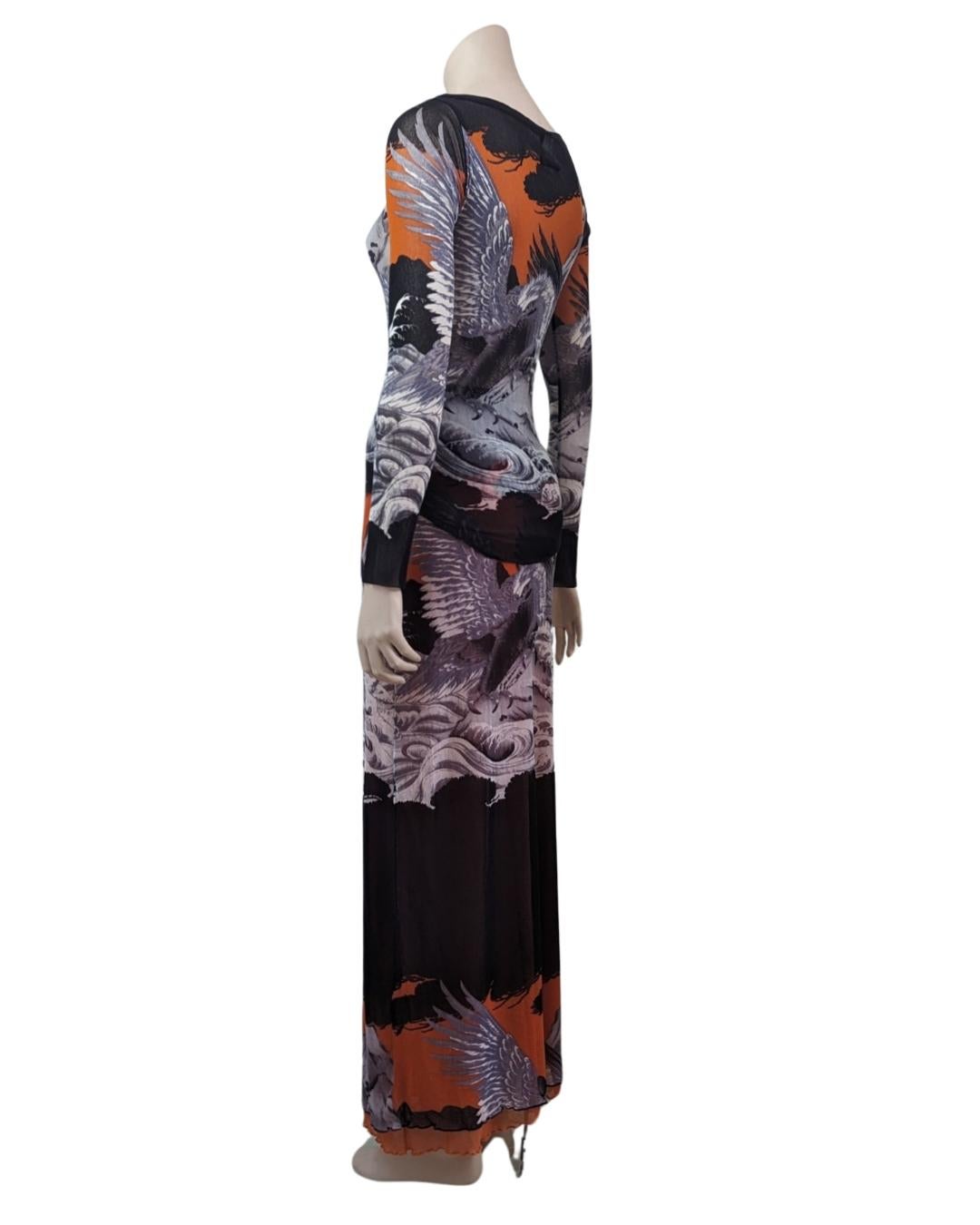 By Jean Paul Gaultier from the Soleil line. Two pieces set featuring a silver eagle and waves with vibrant orange sky tattoo print. Circa 1990s.

· Long sleeves 
· boat neckline
. Mesh
. Maxi Skirt
. Skirt has a double layer of mesh fabric
 

Size
