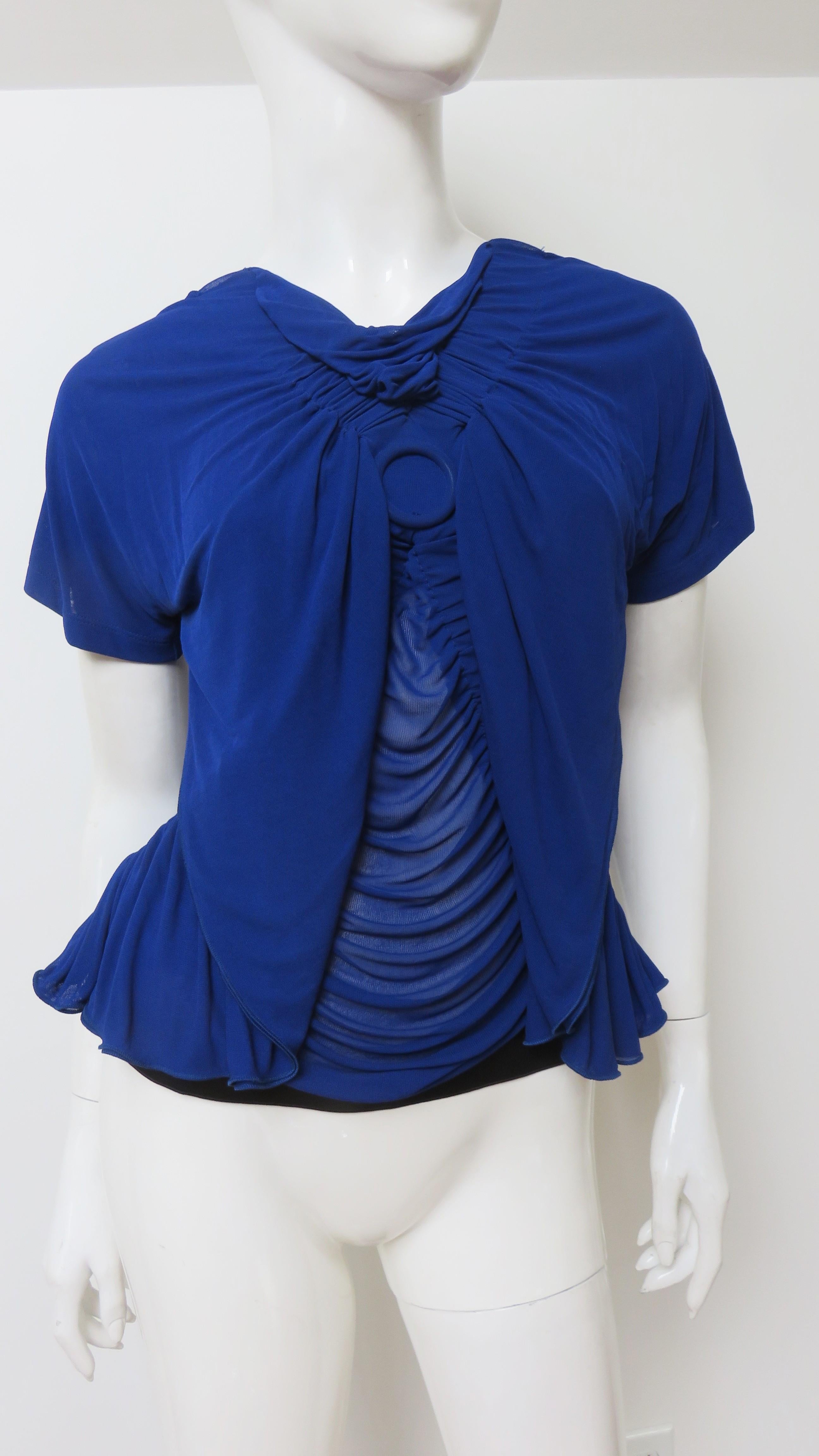 A gorgeous cobalt blue fine knit top from Jean Paul Gaultier. It has short sleeves with a small V neckline, front draping and fabulous black straps under the semi sheer V back matching the black band at the hem.
Fits sizes Small, Medium.  

Bust 