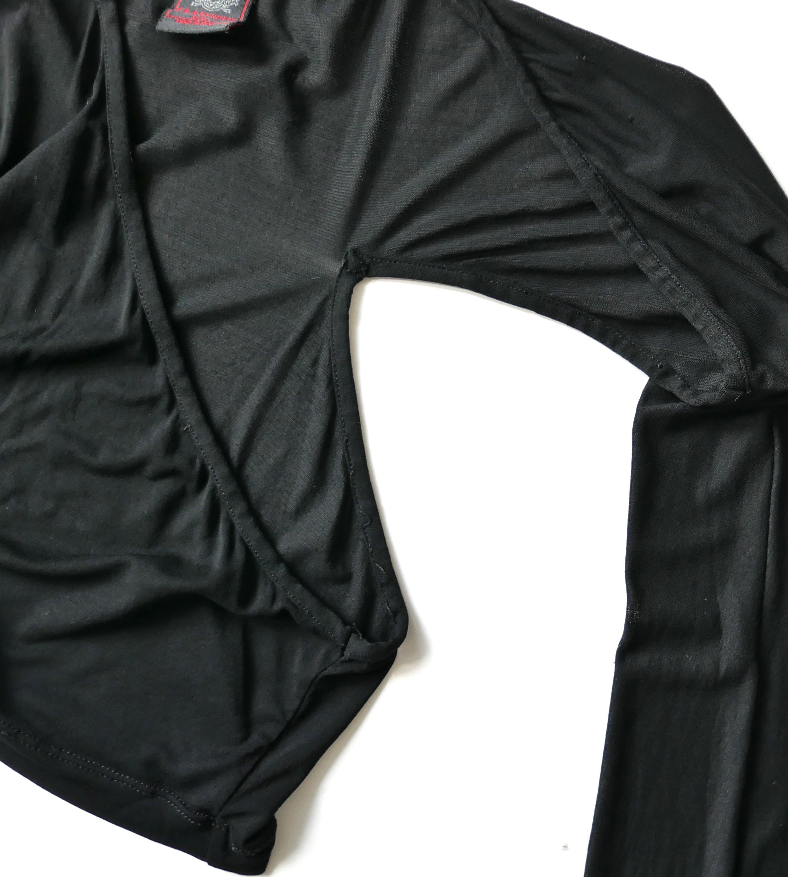 Crop top vintage super cool di Jean Paul Gaultier. Realizzato in rayon nero semitrasparente, morbidissimo ed elastico, ha maniche lunghe e una scollatura asimmetrica con un sexy ritaglio sulle scapole. Taglia IT42/UK10. Misure approssimative senza