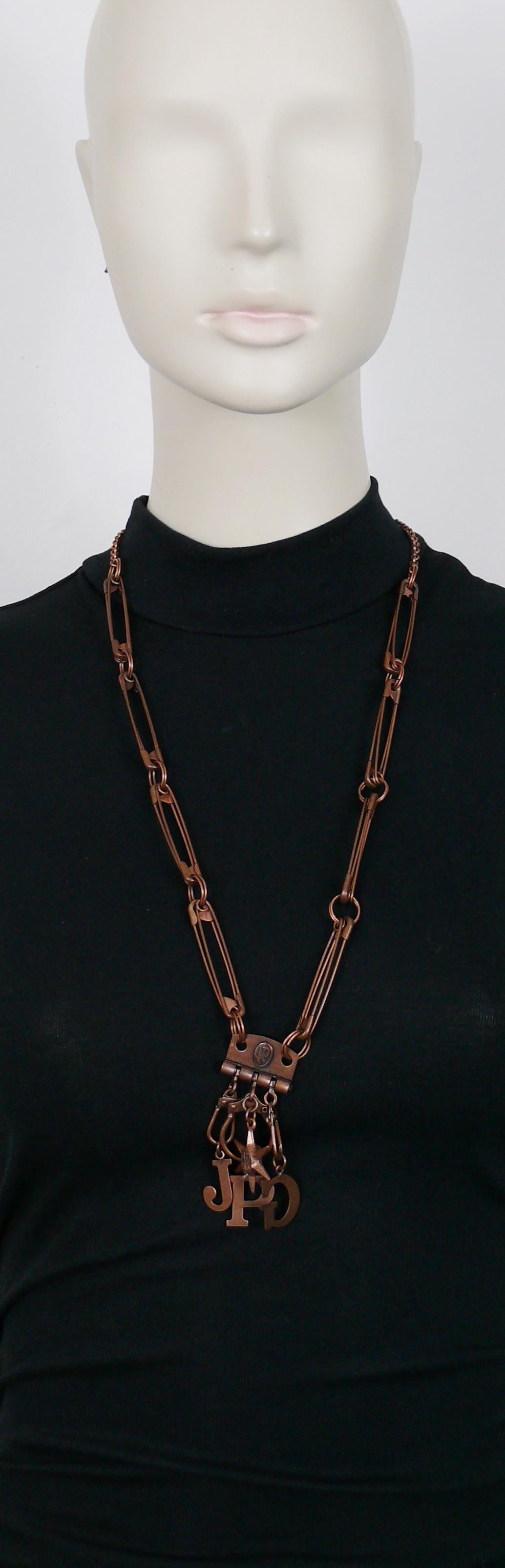 Collana con spille da balia JEAN PAUL GAULTIER vintage in rame anticato con ciondolo portachiavi multiplo con iniziali J. & A. e un ciondolo a forma di stella.

La patina anticata/distorta deriva dal design originale.

Chiusura a