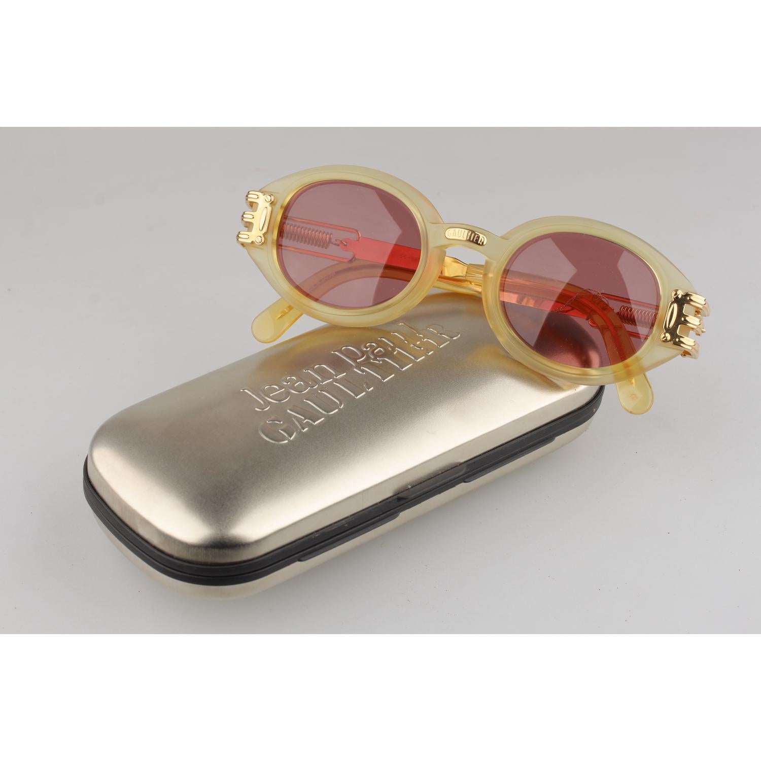 Original Vintage 1990s Jean Paul Gaultier Unisex Sunglasses. Gold frame with honey tone front part. Gold metal arms, with JPG famous gold metal springs on both sides. Paper shop tag still attached. Model and references: 56-5203 - 56/21