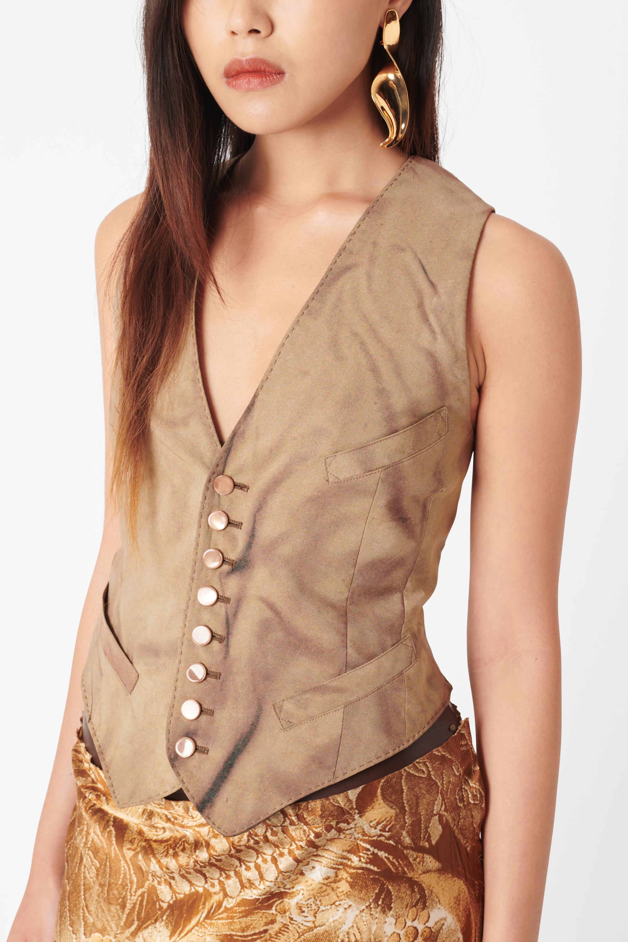 Vintage Jean Paul Gaultier lace back vest. Features backless detailing with adjustable tie up fastening, button down front and non-functional pockets. In excellent vintage condition.

Brand: Jean Paul Gaultier
Color: Brown
Size: UK 8
Modern Size: