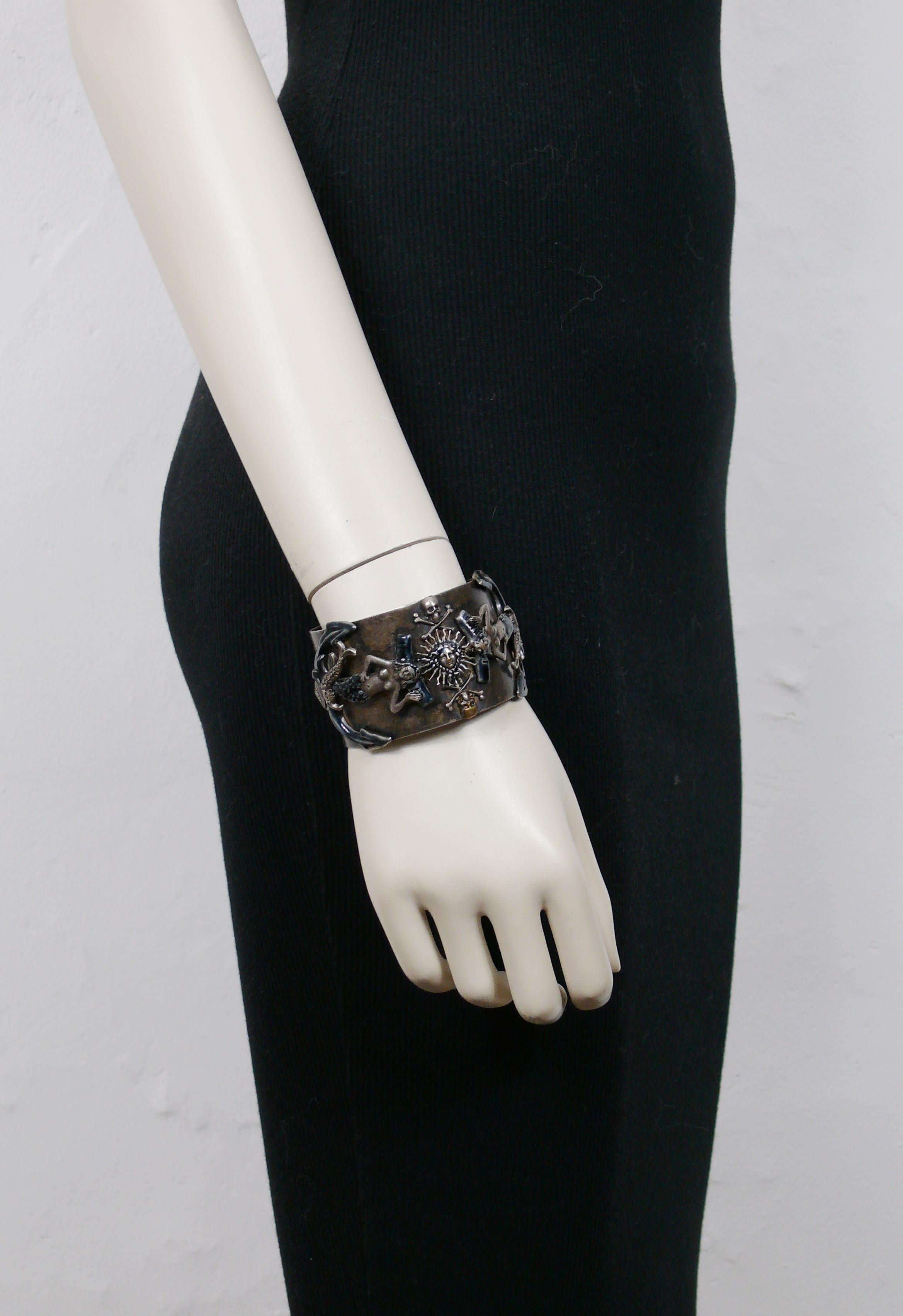 JEAN PAUL GAULTIER vintage dark oxidised metal cuff bracelet featuring mermaids and anchors embellished with blue enamel, dolphins, memento mori and radiant sun face.

The dark oxidised patina is from original manufacturing.

Marked
