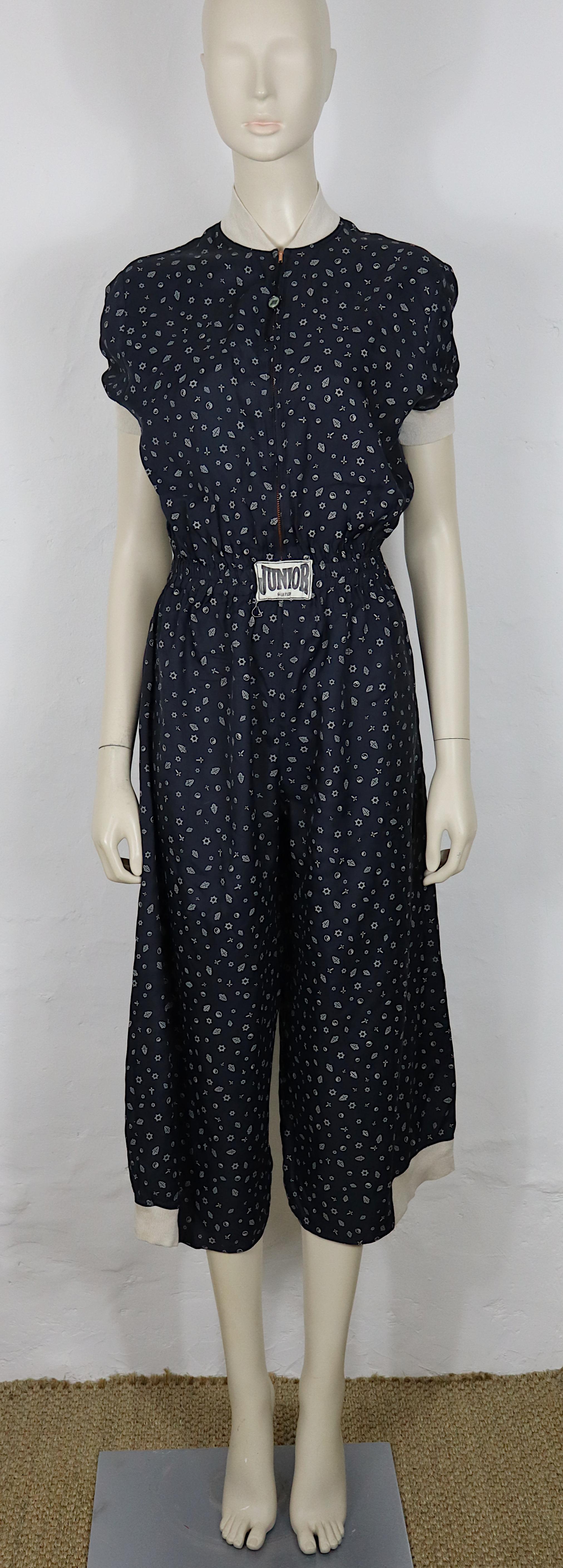 Combinaison vintage JEAN PAUL GAULTIER (ligne JUNIOR GAULTIER) en tissu léger bleu marine, ornée d'un imprimé composé de symboles syncrétiques - dont le yin-yang, la main Hamsa, la croix et l'étoile de David - créant un motif visuellement riche et