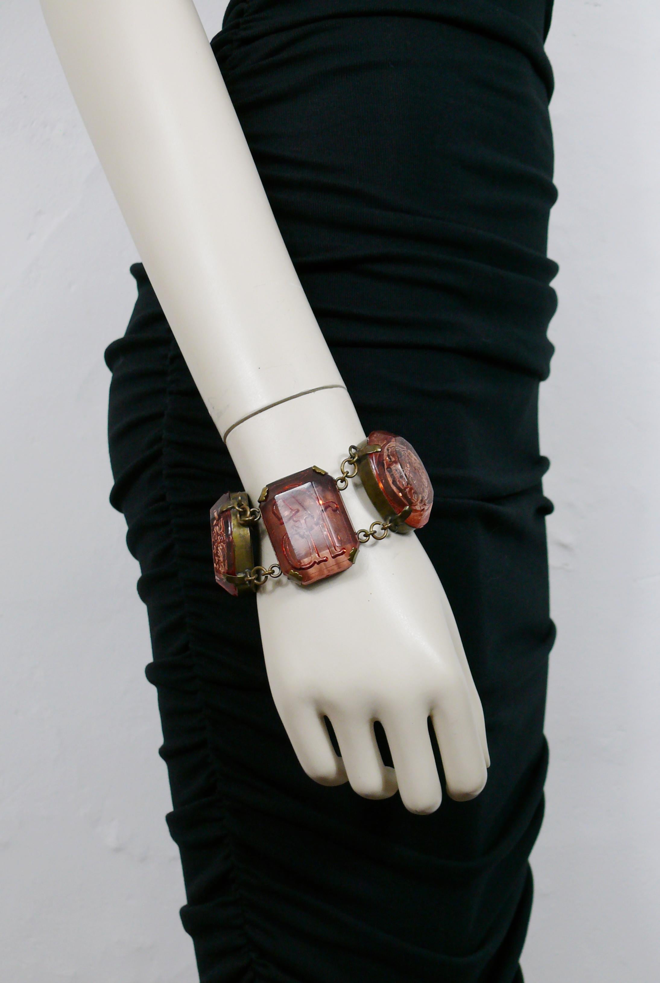 JEAN PAUL GAULTIER vintage antiqued bronze toned bracelet featuring five large strawberry color resin links featuring inlaids with scarabs, ancient roman cameo profiles and a JPG logo.

The antiqued bronze toned and distressed patina is from