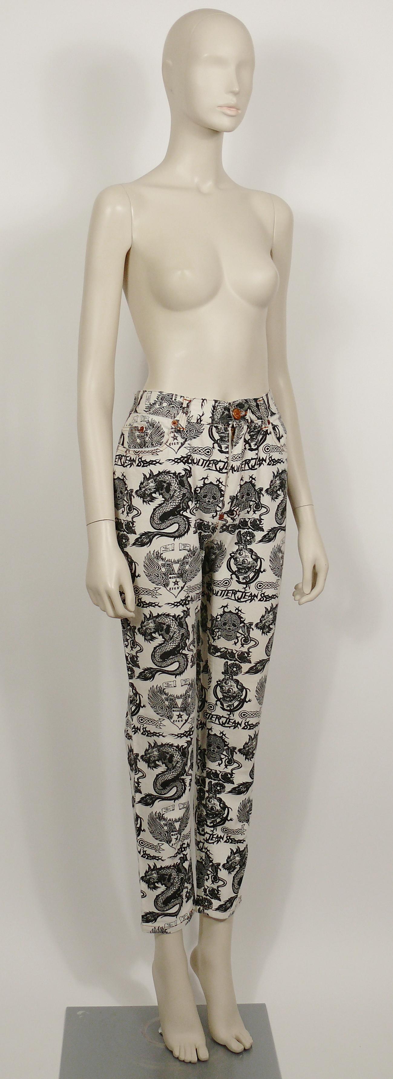 JEAN PAUL GAULTIER Vintage-Hose in Off-White mit schwarzem Tattoo-Aufdruck von Stacheldraht GAULTIER JEAN'S, Drachen, Totenköpfen und Doppelkopfadlern.

Diese Hose hat folgende Eigenschaften:
- Off-white Baumwollmischgewebe mit schwarzem