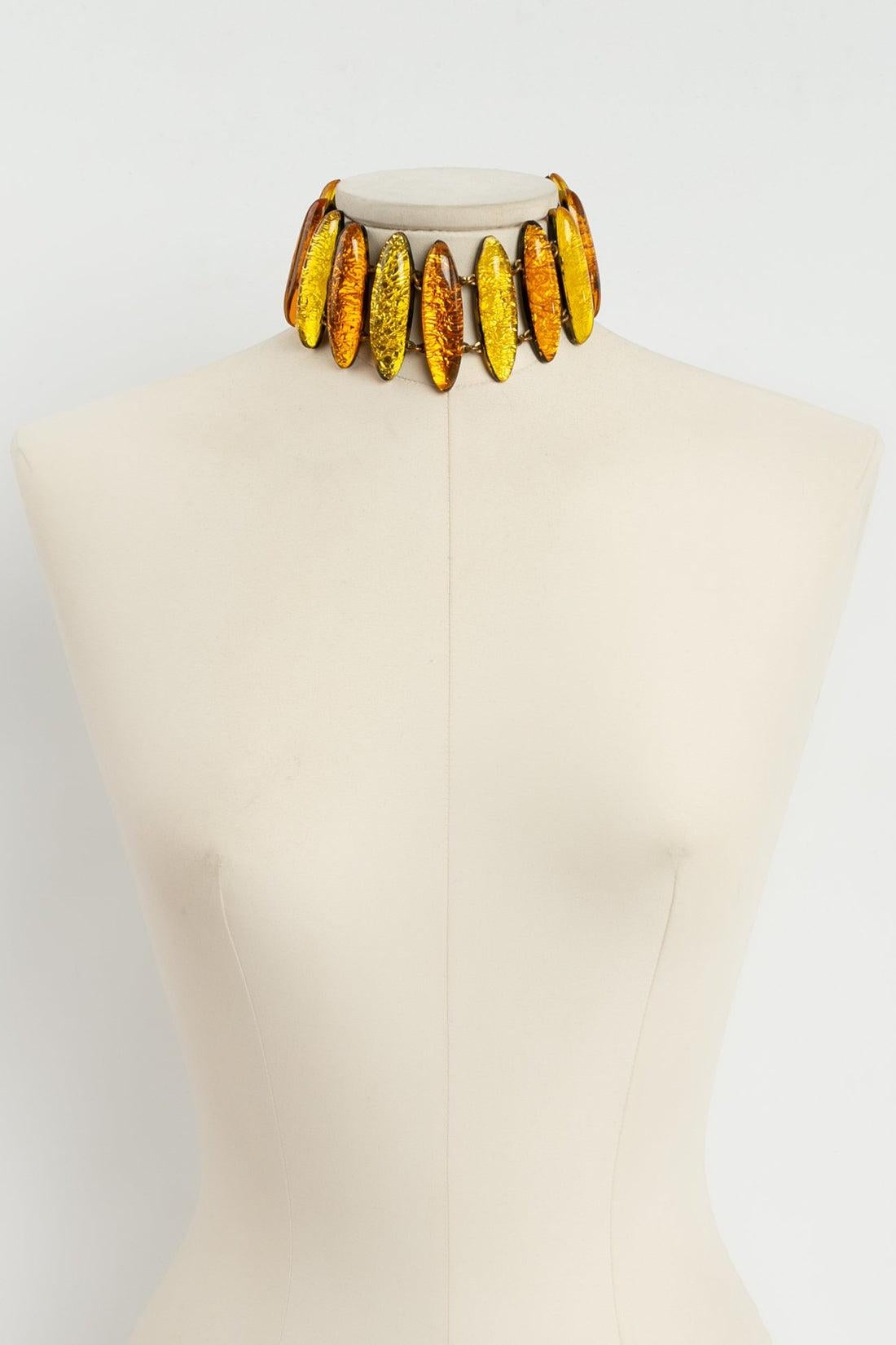 Jean Paul Gaultier - Articulated gilded metal choker paved with resin in yellow, orange and tortoise-shell colors. Signed at the tip.

Additional information: 
Dimensions: Width: 30.5 cm to 34 cm (12