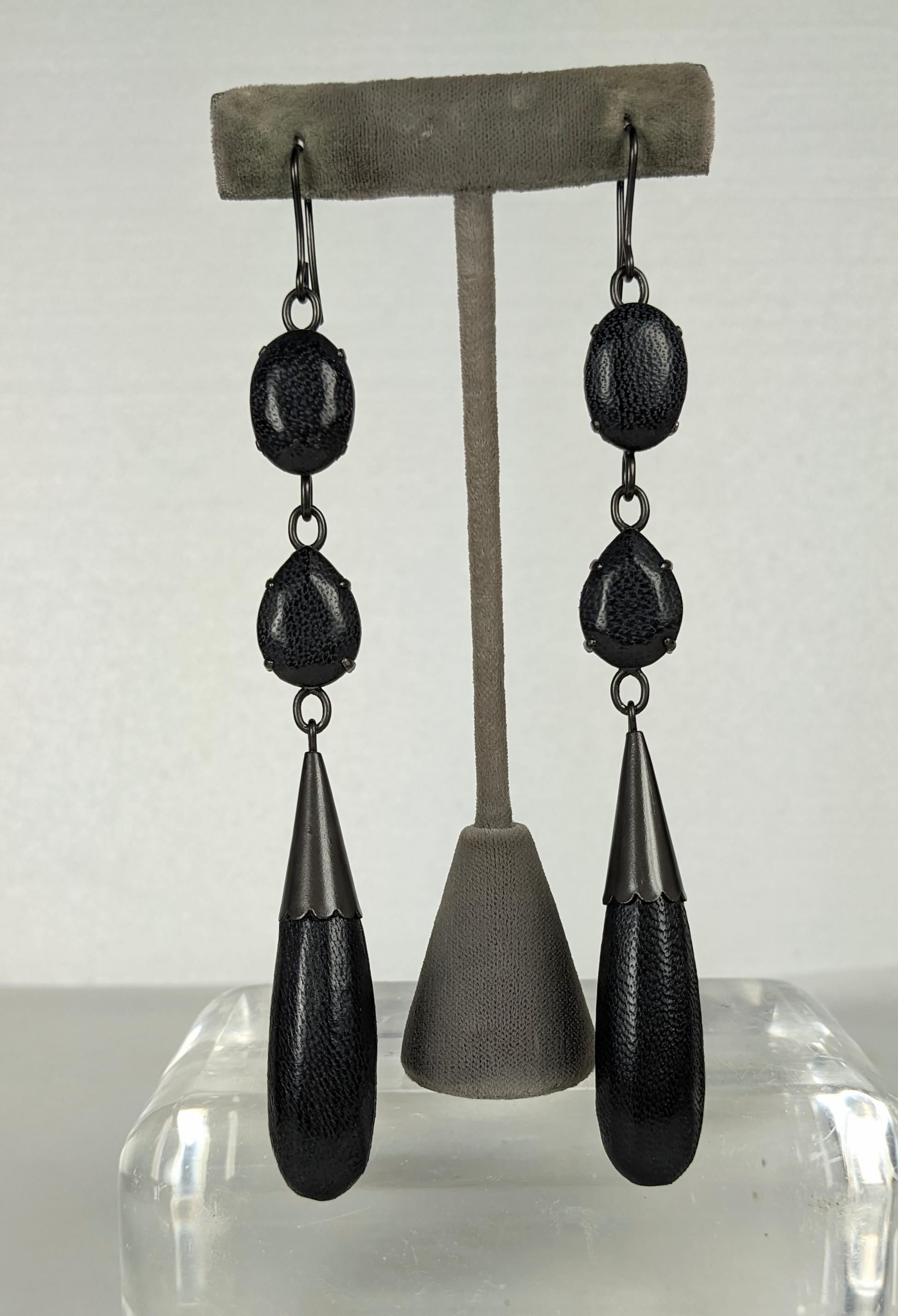Unusual Jean Paul Gaultier Long Leather Earrings. Composed of oval cabocheons, faceted teardrops and long tear drop pendants, all sheathed in black lamb skin leather. All set in blackened bronze metal. Signed Jean Paul Gaultier, Excellent Condition.