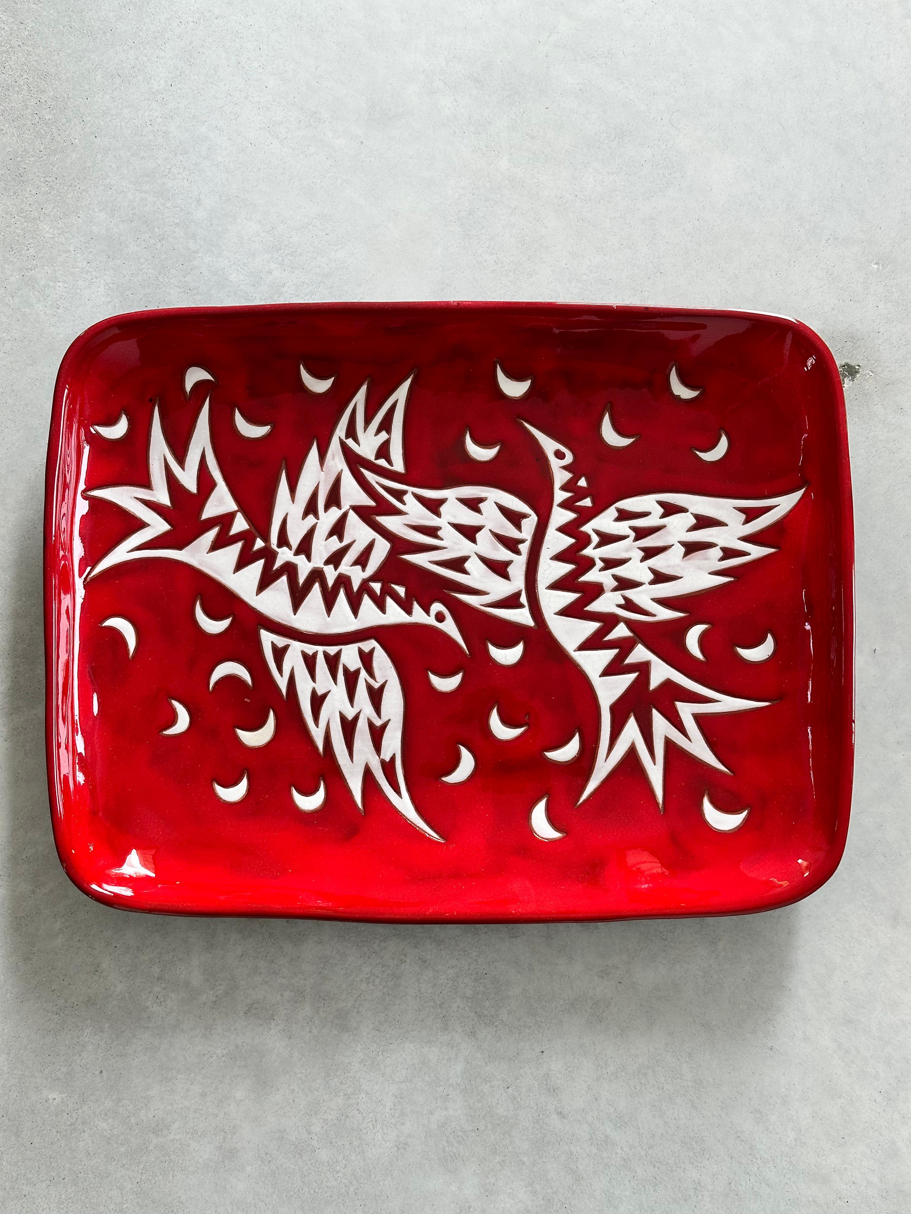 Grand plat en céramique provenant des ateliers de poterie Sant-Vicens à Perpignan (sud de la France).

Dessin réalisé par Jean Picart Le Doux.

Deux oiseaux stylisés blancs sur un fond rouge intense.

Série limitée à 50 exemplaires, celui-ci est