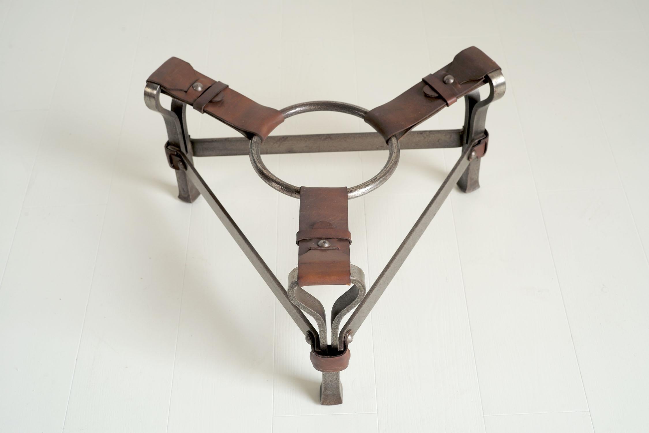 Jean-Pierre Ryckaert, wrought iron and leather coffee table base, France 1950. Tripod-shaped, this creation combines heavy-section wrought iron and fawn leather parts enhanced with large rivets. A large ring hangs in the center.
