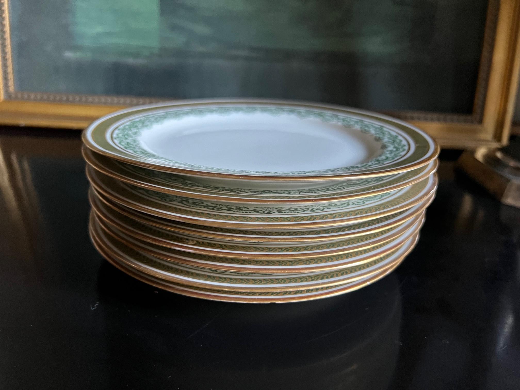 Set of eight Limoges salad / dessert plates made in France by Jean Pouyat between 1890 and 1902. The plates are a bright white with green scrolling around the inside edge with green laurel on a gold band on the outer rim.

The stamp on each plate
