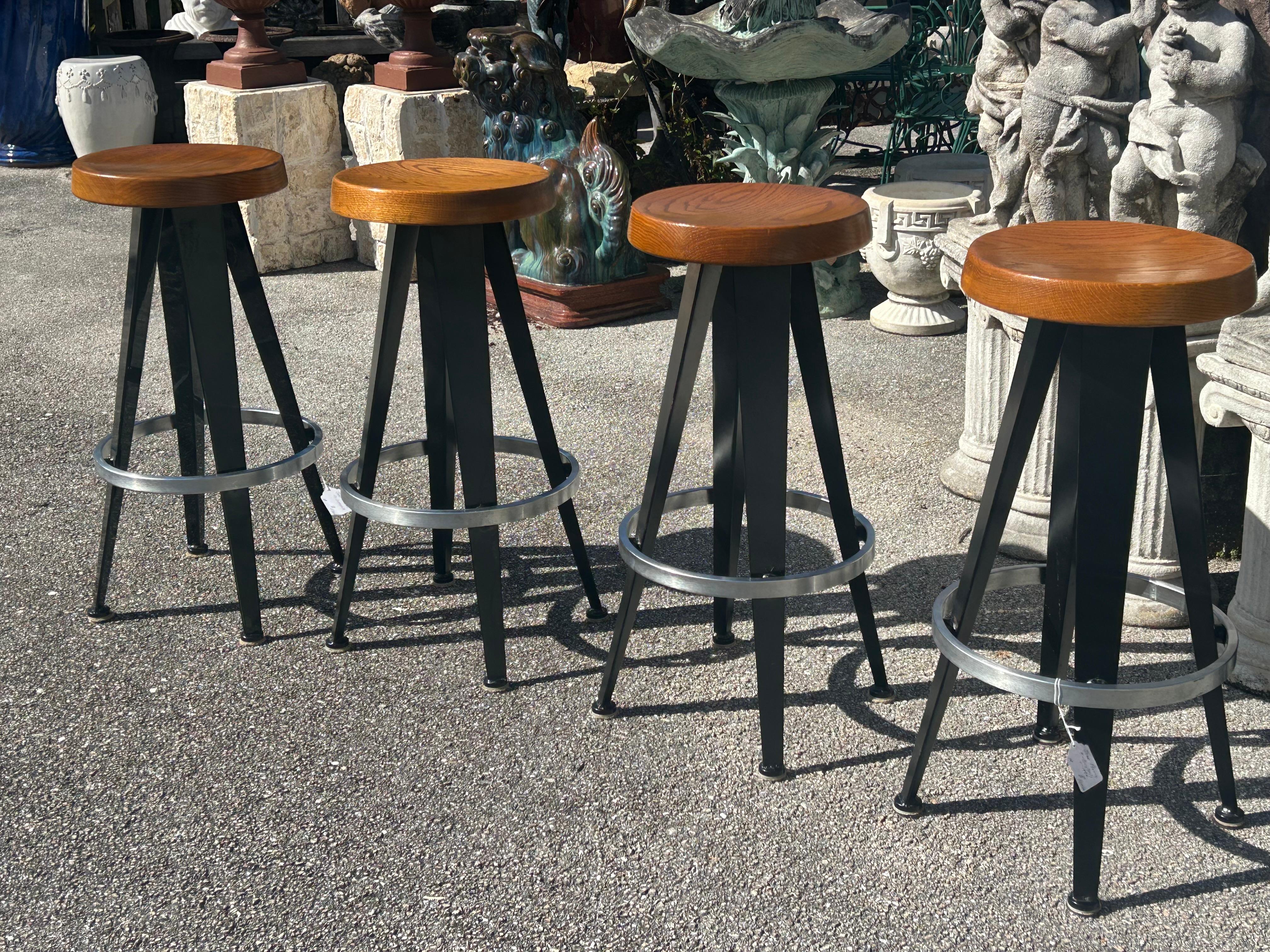 Modernist barstools after Jean Prouve circa 1990… barstools in black enameled metal… Brushed aluminum footrest ,and oak seats with a concave center…Very solid construction incredible detail… .. there are four of these stools available. They are in