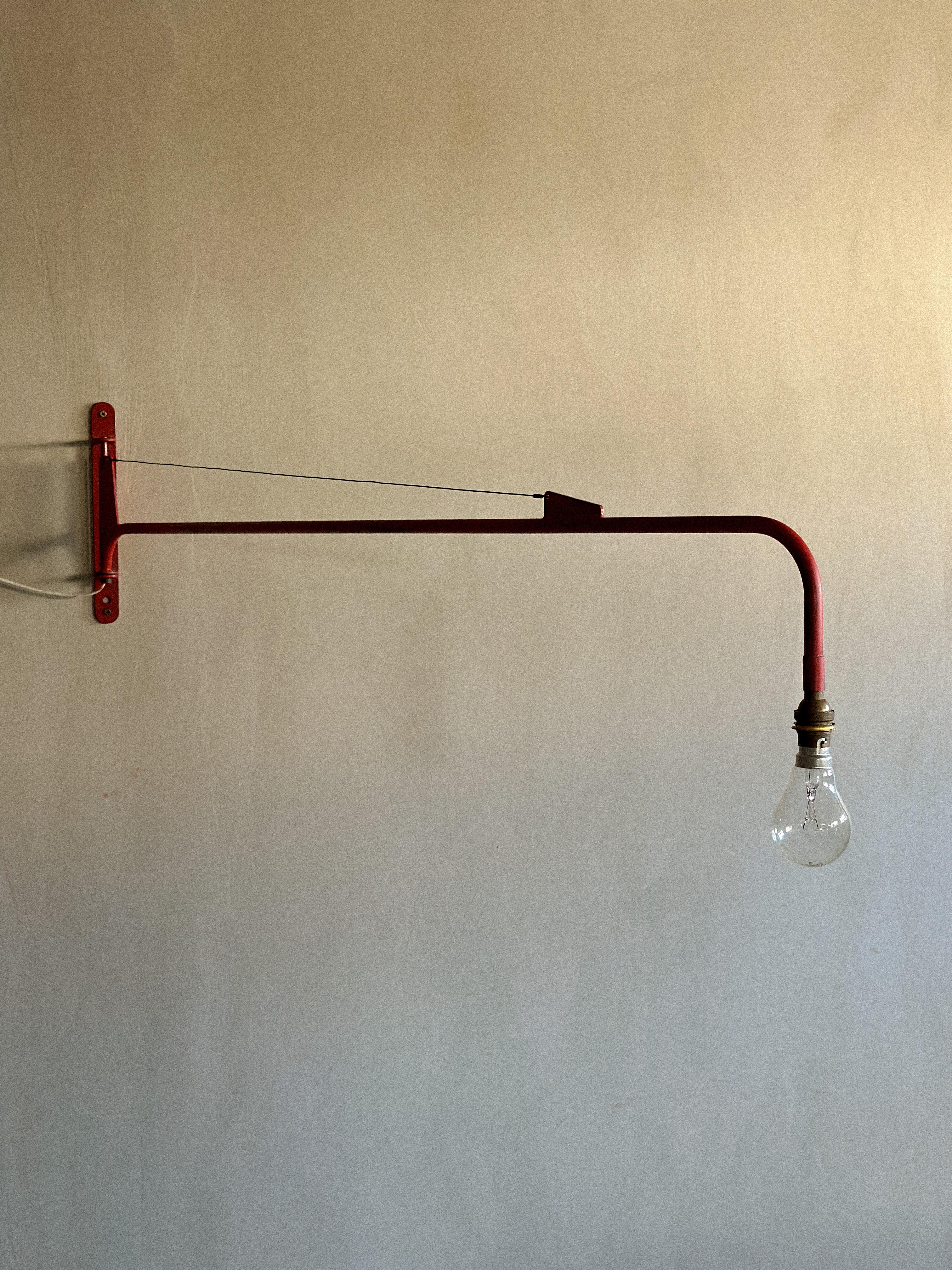 Original red painted Swing-Jib lamp from France, c. 1950s, attributed to Jean Prouvé. Steel tube, sheet, cable. 

Wear consistent with age and use 

W: 120, H: 28 cm, D: 3 cm 