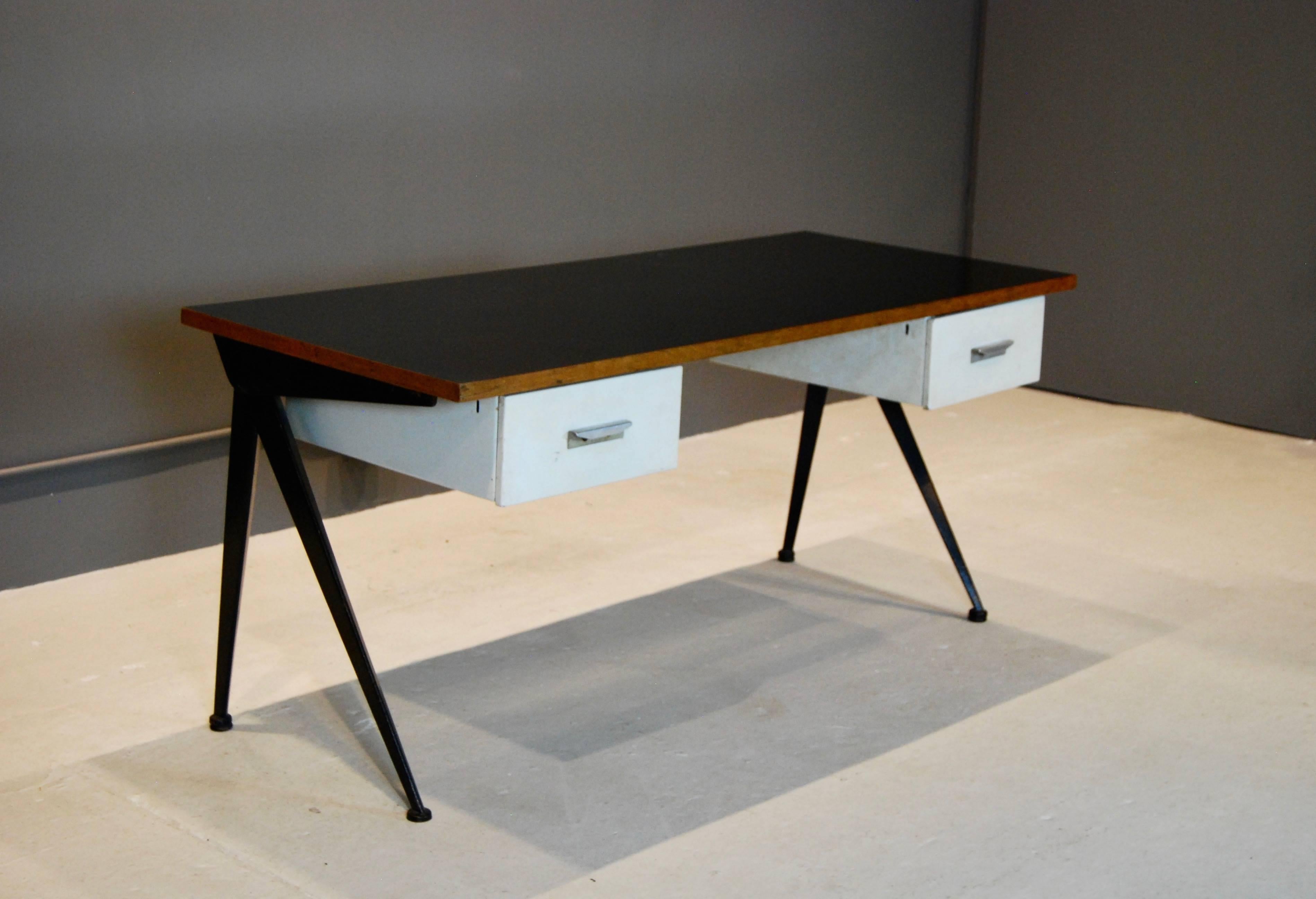 Iconic Compas desk, created by Jean Prouve and manufactured by Atelier Prouve in the 1950s.
Compas- shaped legs support black laminated wood top and two steel drawers.
This desk is in all original condition.
Great style and function.