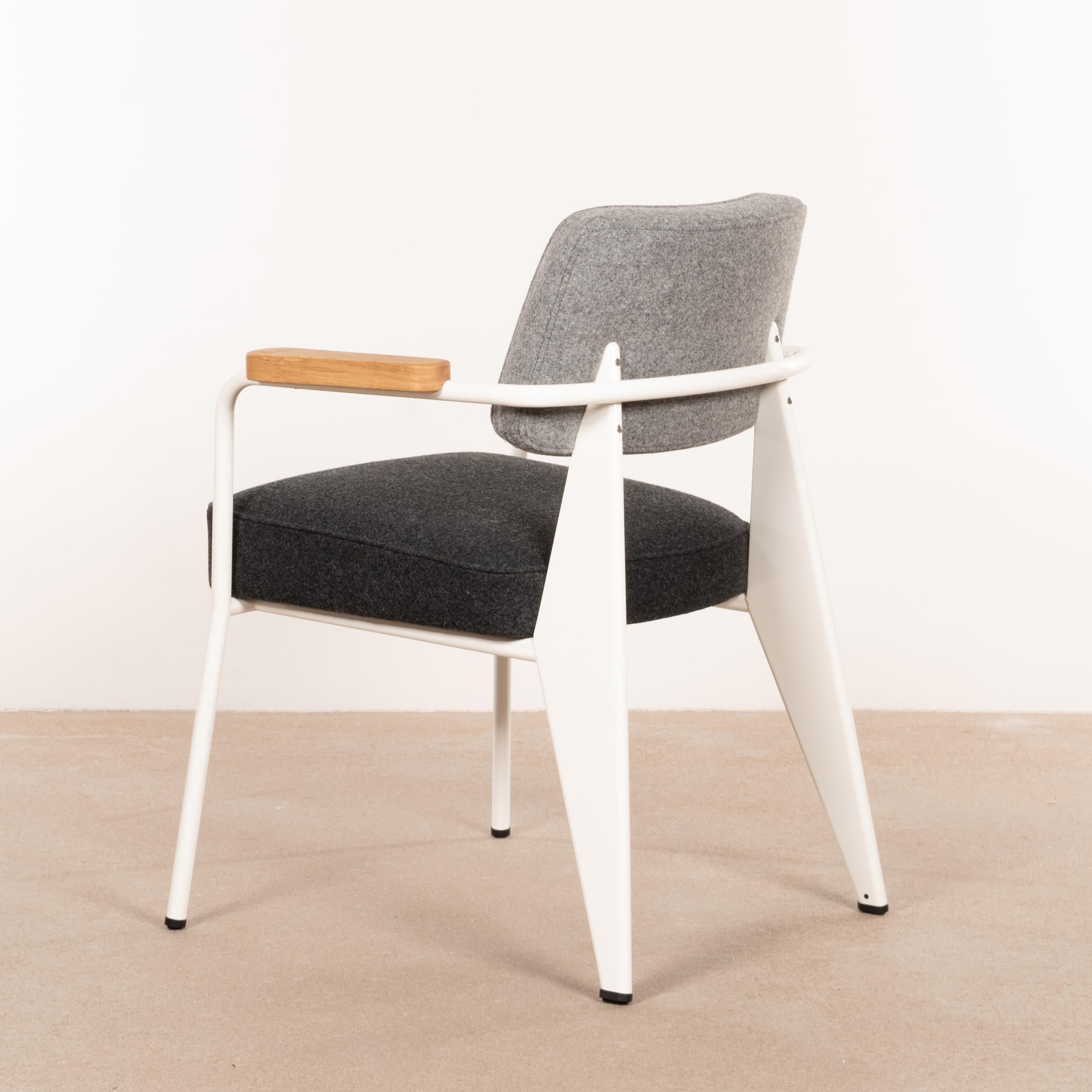 Iconic Fauteuil Direction designed by Jean Prouvé in 1951 and manufactured by Vitra in 2019. White powder-coated frame with cushions in dark en medium grey wool. Excellent new condition and labelled. Currently two chairs available.