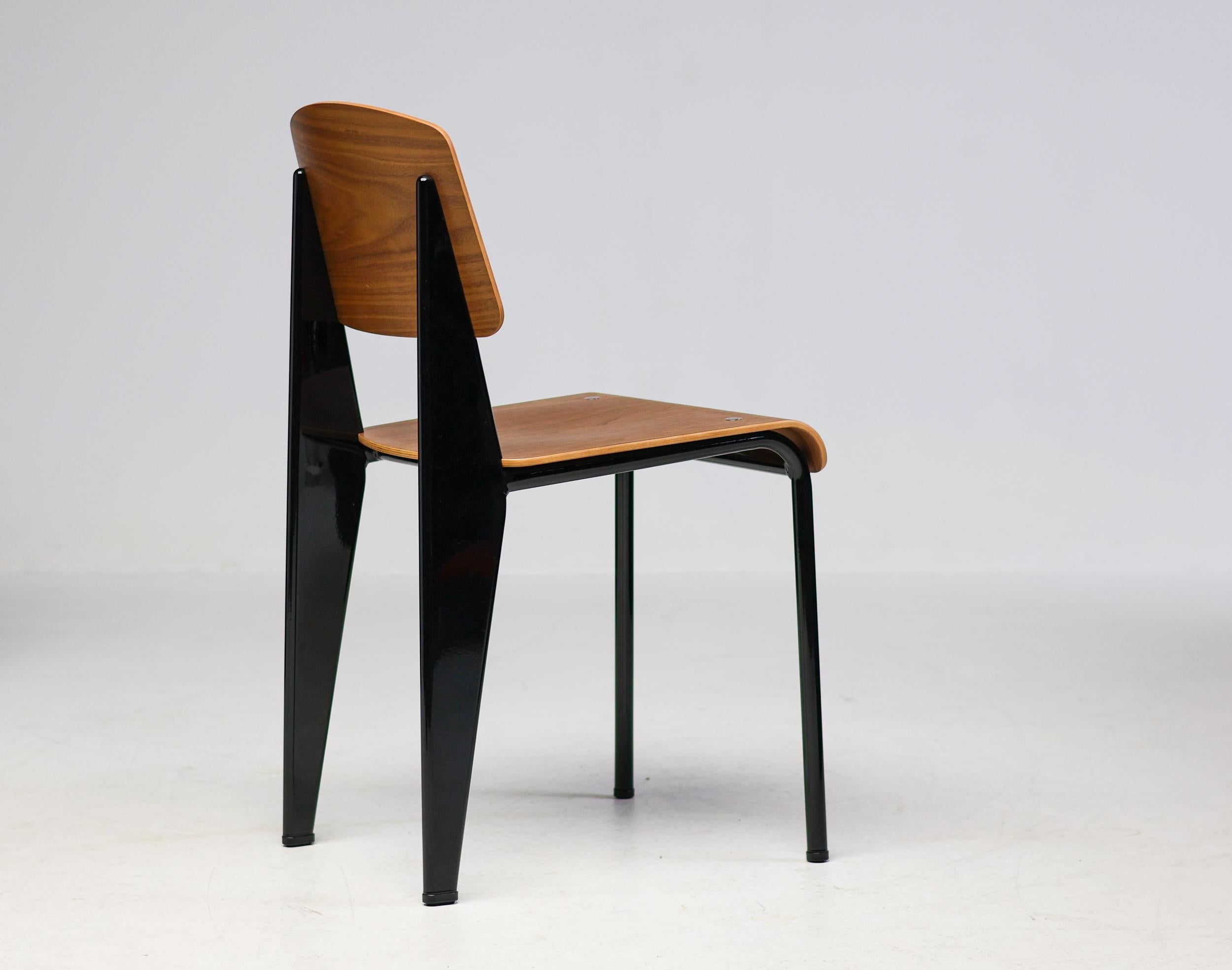 Der klassische Standardstuhl wurde ursprünglich 1934 von Jean Prouvé entworfen.
Dieses schöne Exemplar ist aus Nussbaumholz gefertigt und hat einen schwarz emaillierten Stahlrahmen.
Markiert mit Label.

Jean Prouvé war ein französischer