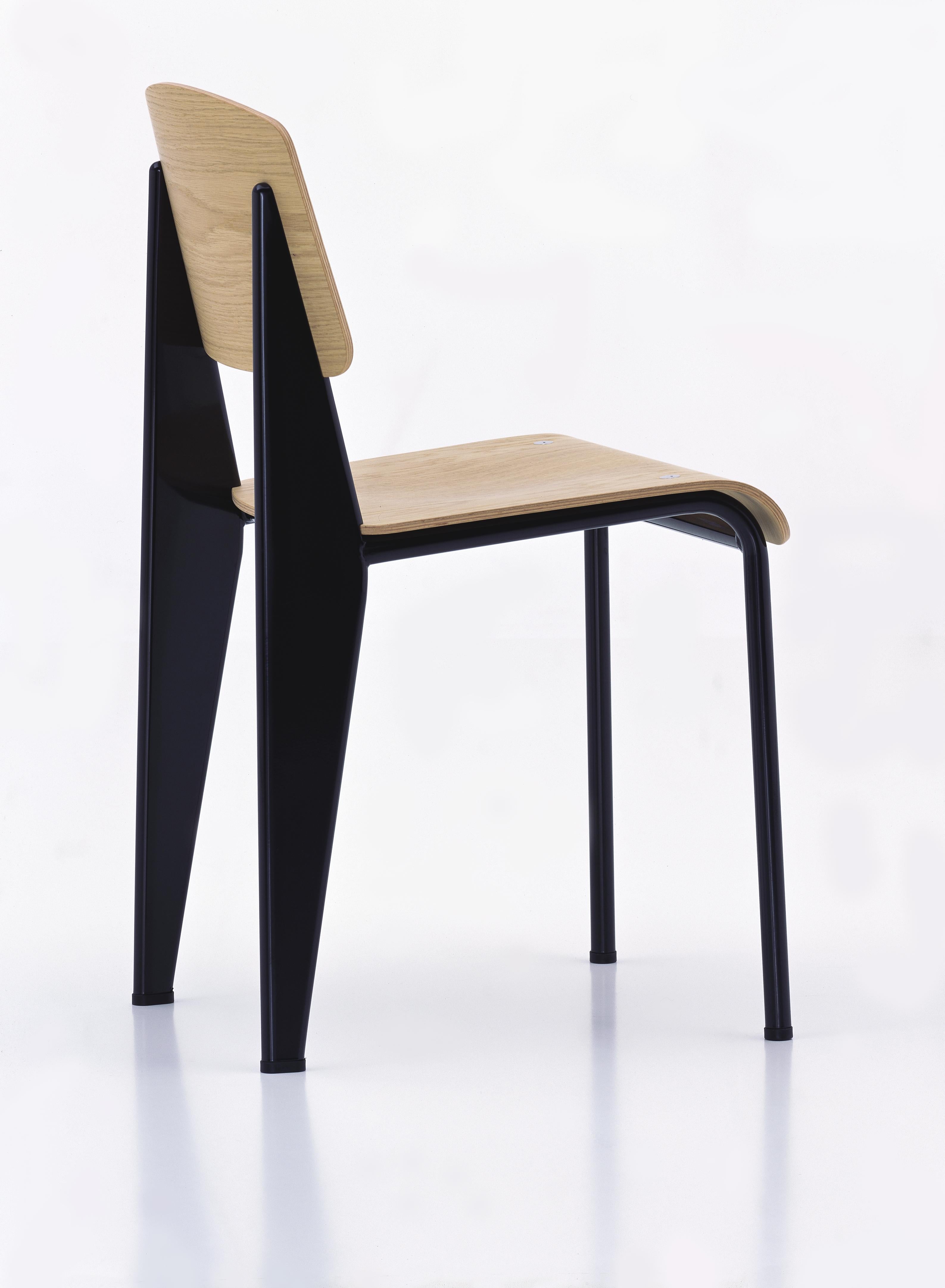 Jean Prouvé Standardstuhl aus Eiche natur und schwarzem Metall für Vitra. Der Standard-Stuhl ist ein frühes Meisterwerk des französischen Designers und Ingenieurs Jean Prouvé. Ursprünglich 1934 entworfen, entwickelte sich der Standard zu einem der