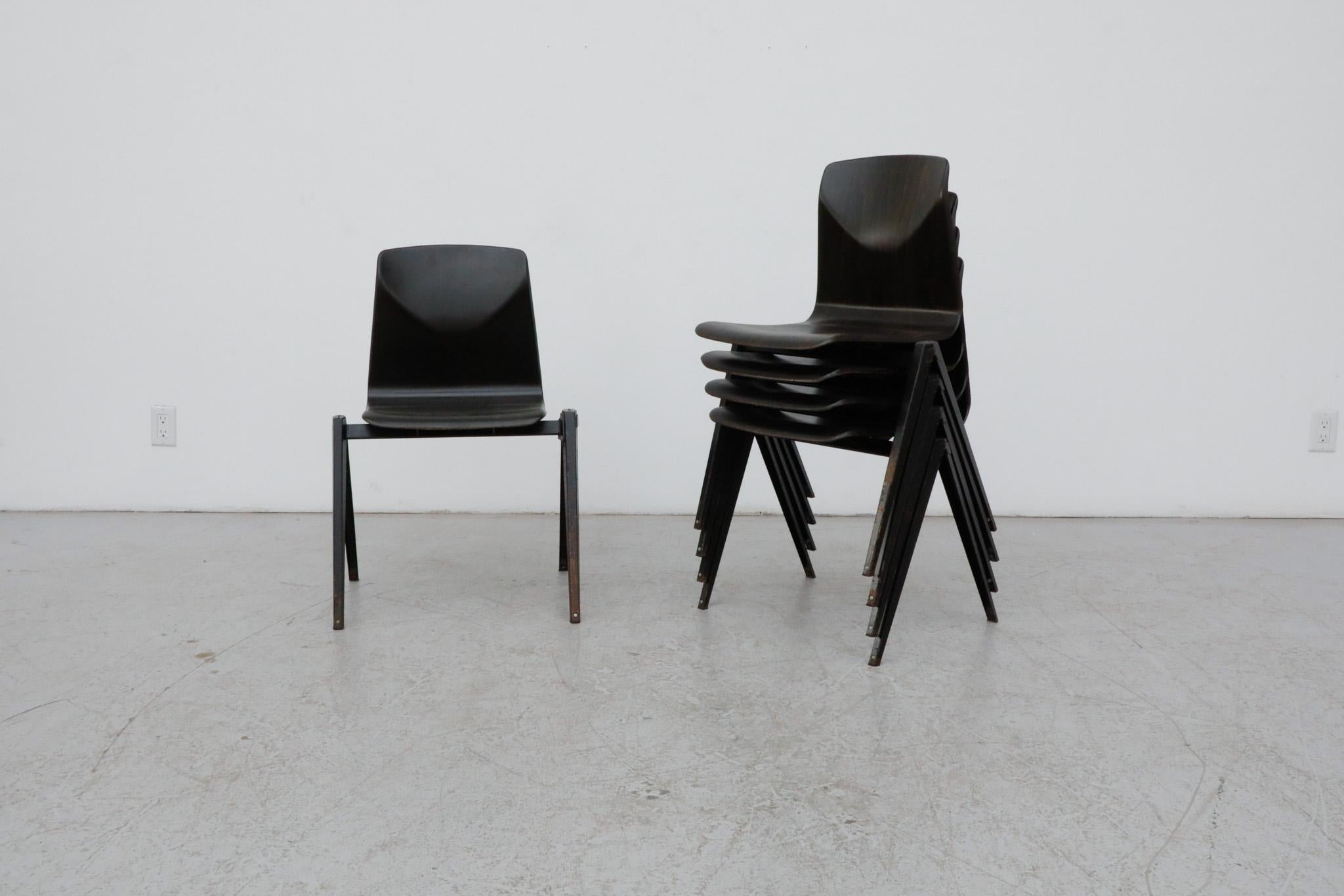 Prouve style, Mid-Century, wenge toned industrial stacking chairs with attractive compass base, dark charcoal enameled metal frame and ingeniously interlocking legs that can create rows of seating. These are in original condition with some visible