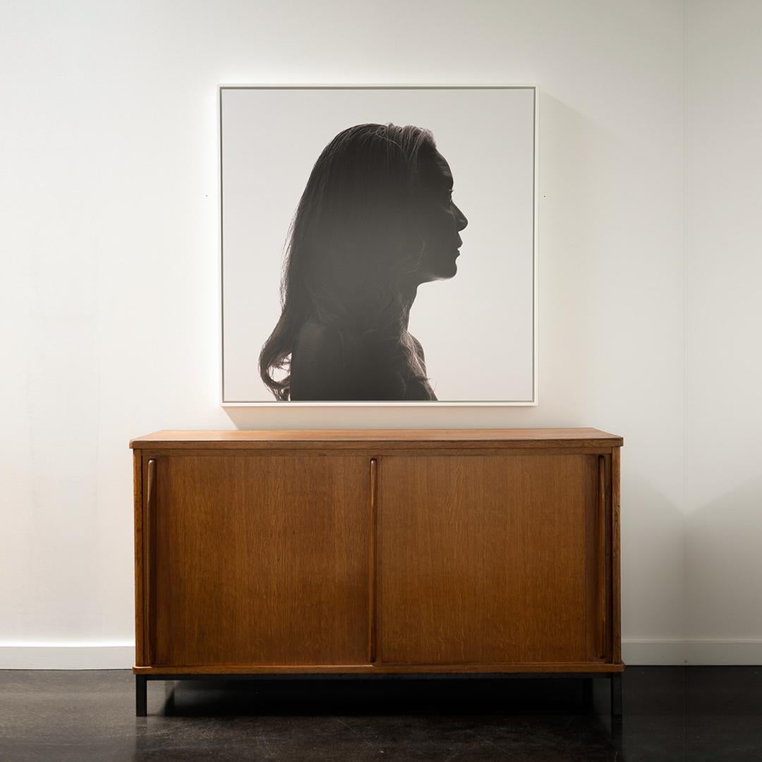 Crafted in the style of iconic French designer Jean Prouvé, this mid-century modern sideboard pairs functional clarity with refined construction. Made from warm-toned oak, the piece features minimalist integrated pulls and sliding doors that conceal