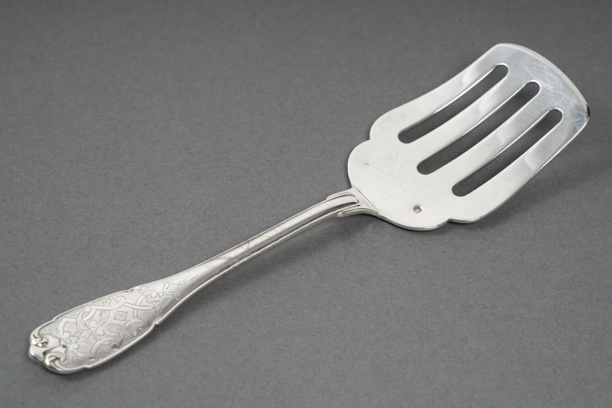 Pelle à poisson en argent massif, le manche est ciselé avec un décor Bérain mettant en valeur le mat et le brillant. Le serveur est percé. Petit numéro sur la spatule. Bon état, rayures d'usage.

Dimensions : Longueur : 22 cm 6 Largeur maximale : 6