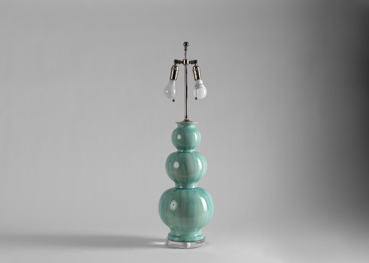 This pair of table lamps are glazed in a serene duck egg's blue and composed of three spheres stacked in graduated size.