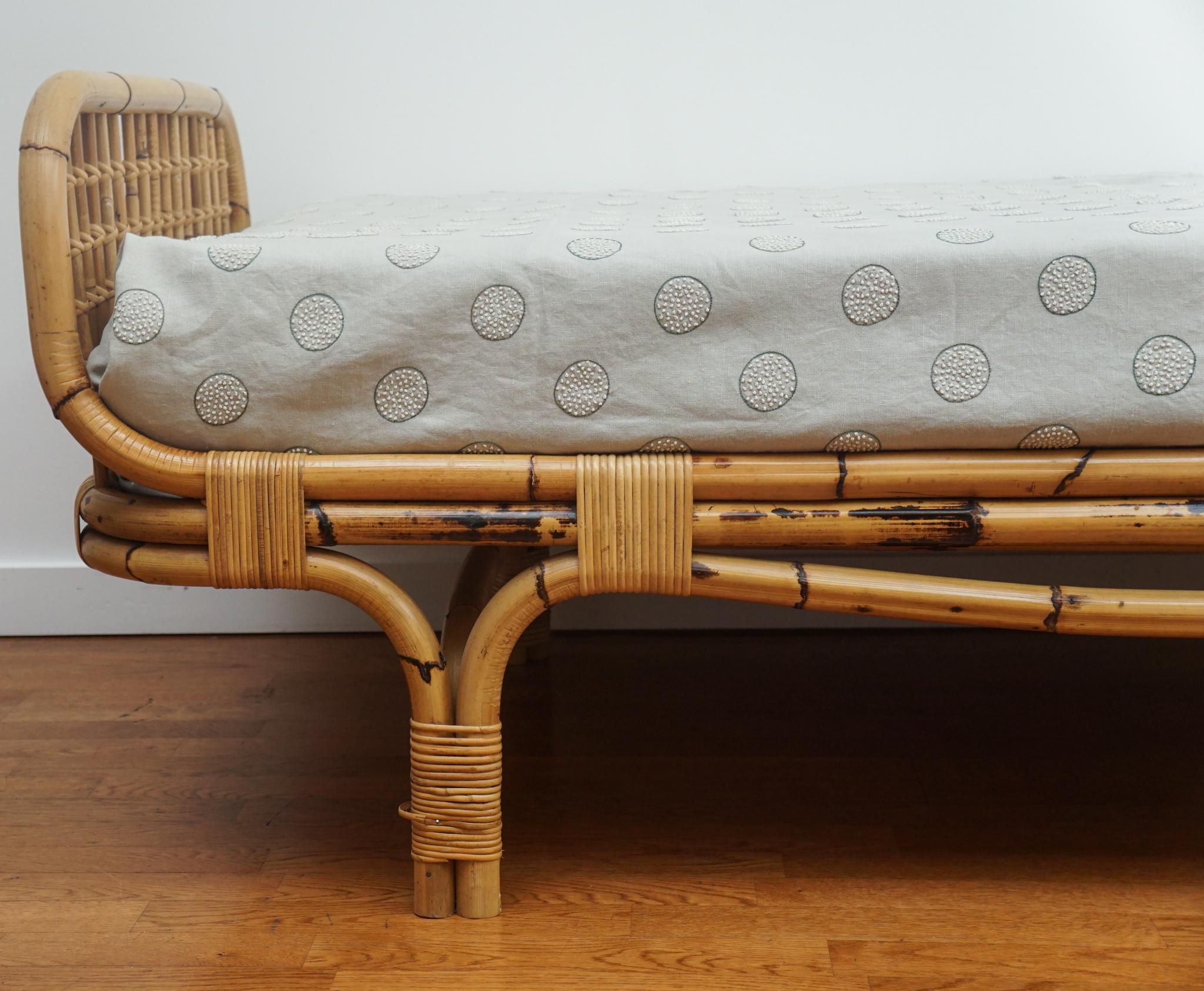 The French bamboo daybed, shown here, was made in the 1960s.  Solidly built and in very good vintage condition, the bamboo daybed is distinguished by its low profile design, graceful lines and warm, honey-colored patina.  The mattress, which is new