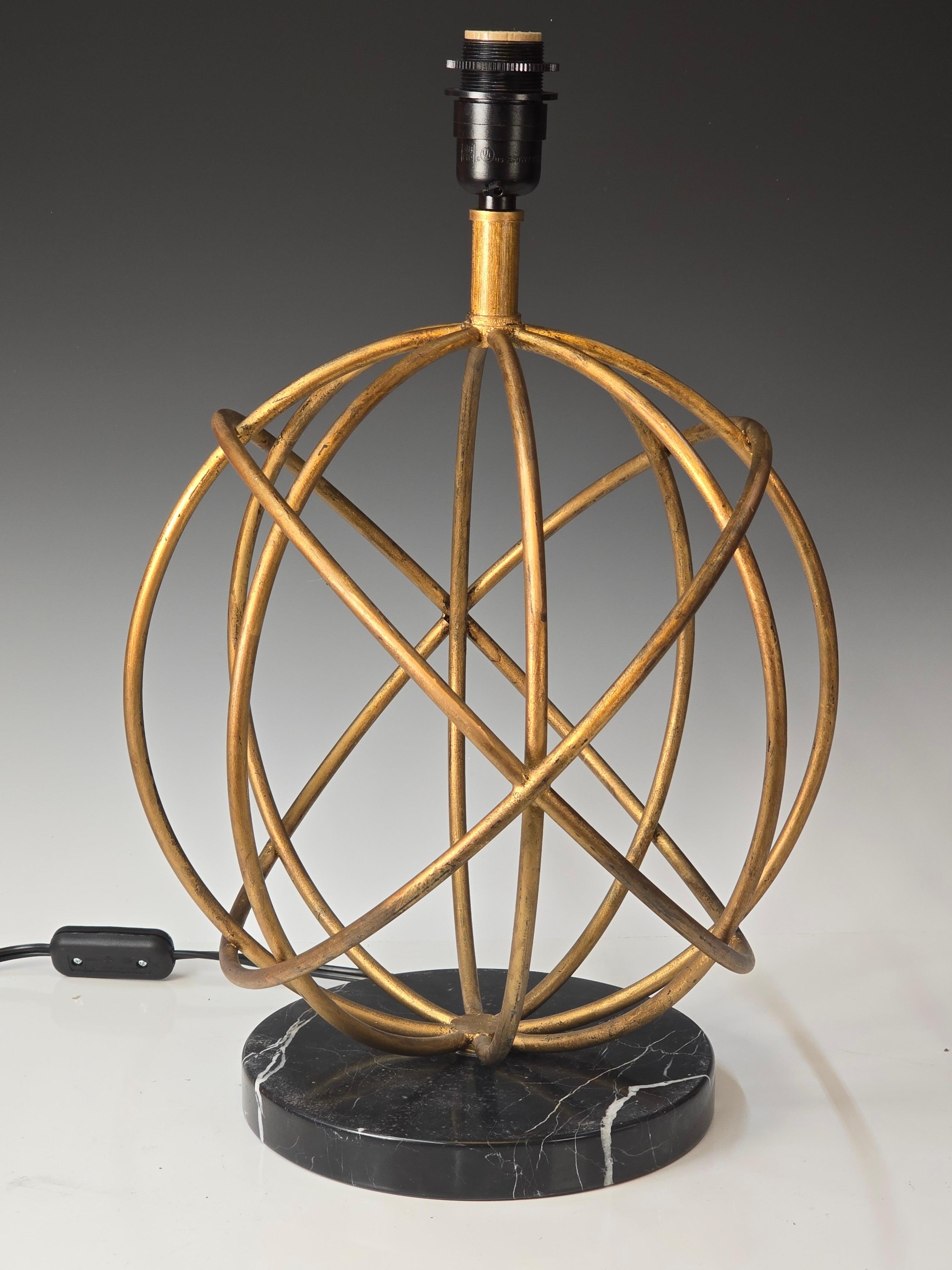 Gorgeous gilt iron lamp inspired by the designs of Jean Royere.   Round black marble base supports a gilt iron globe the has the wires internally routed with a high end black painted  machined brass socket that is meant to hold the shade.