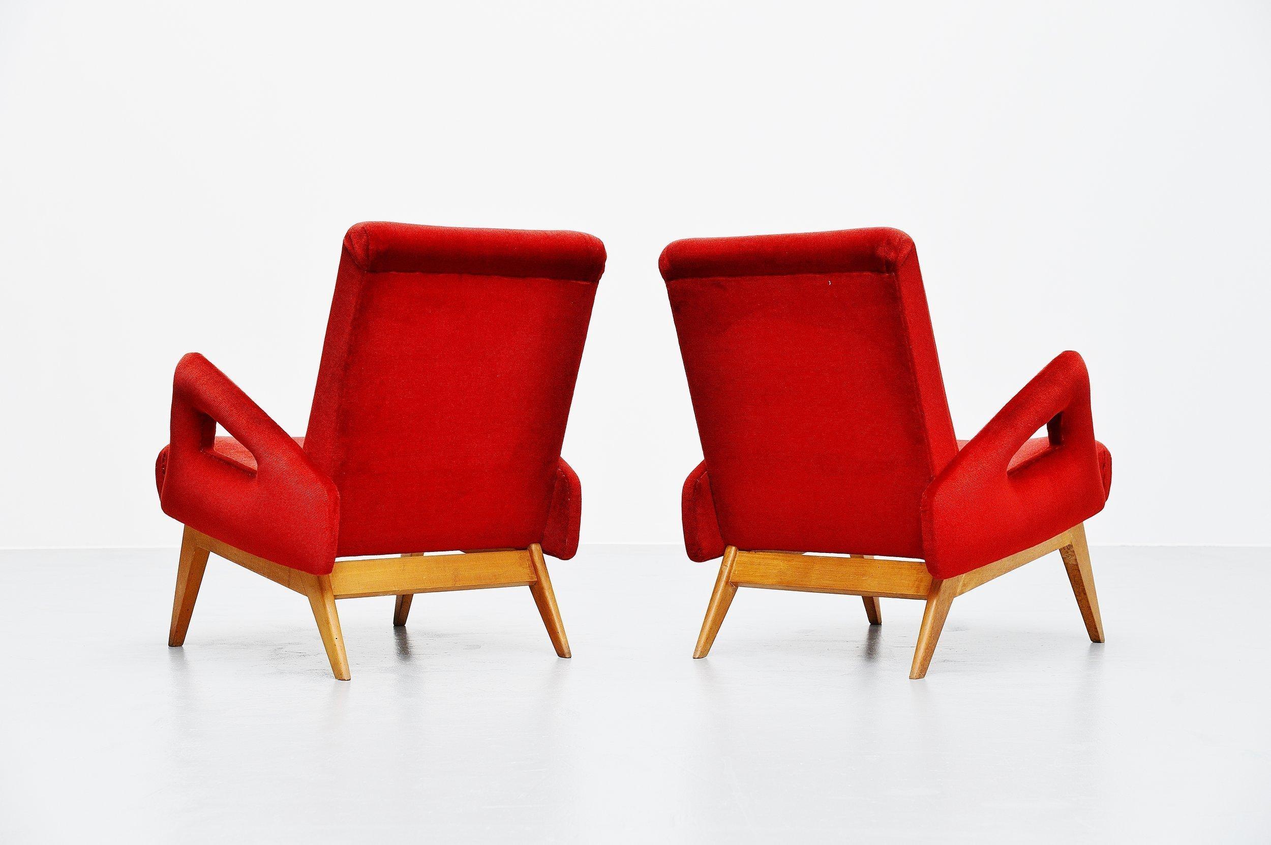 Very nice and unusual shaped lounge chairs, France, 1950. These chairs have solid beech wooden legs and red velvet upholstery which is still fully original. Fantastic shaped lounge chairs, unusual shaped arm rests but very lovely. The upholstery is