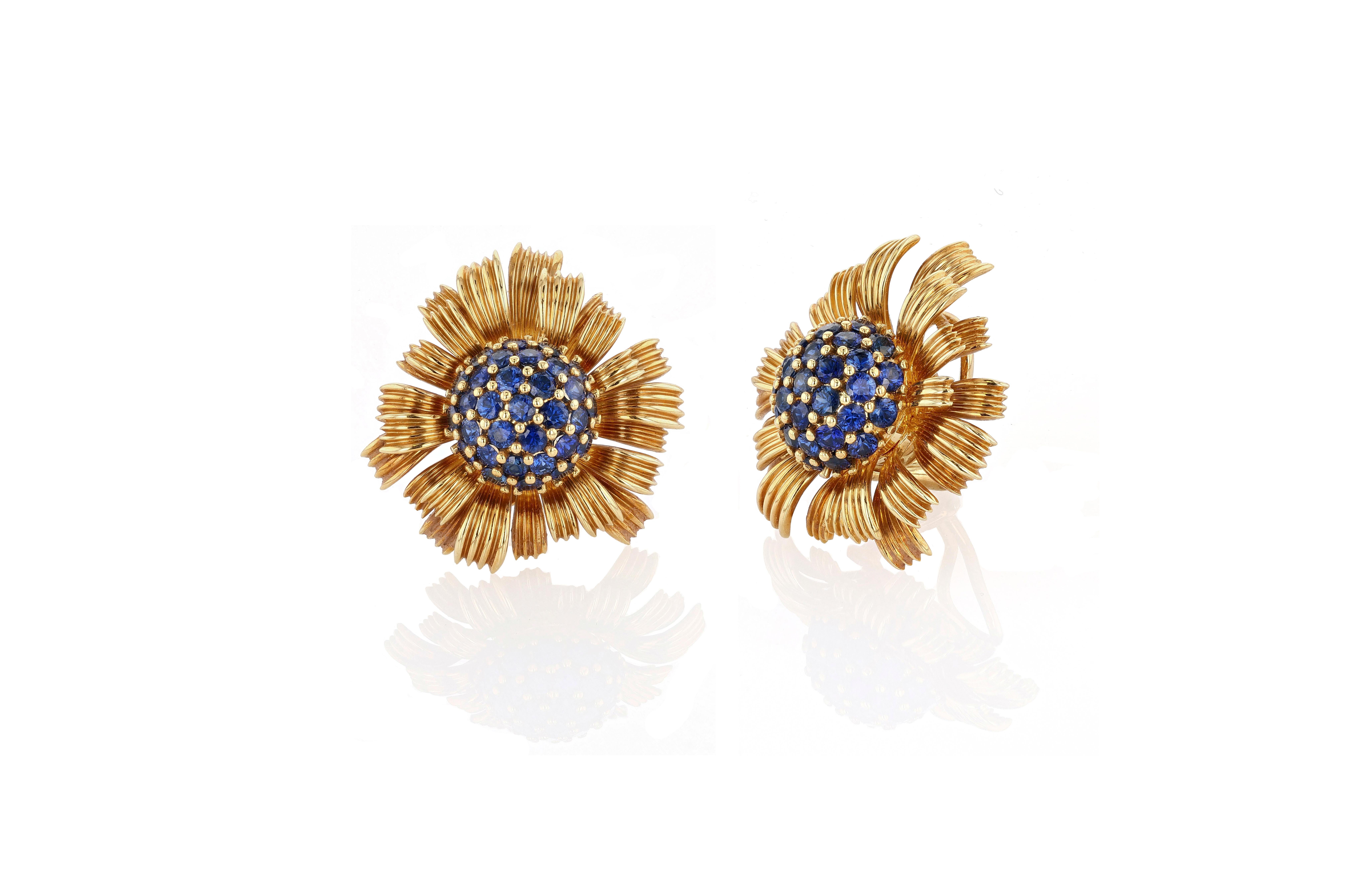 A pair of exceedingly rare and sought after “Dahlia” ear clips by the genius artistic mind of Jean Schlumberger for Tiffany & Co. The ear clips center pave sapphire flower centers which are surrounded by fluted petals of various sizes, lengths, and