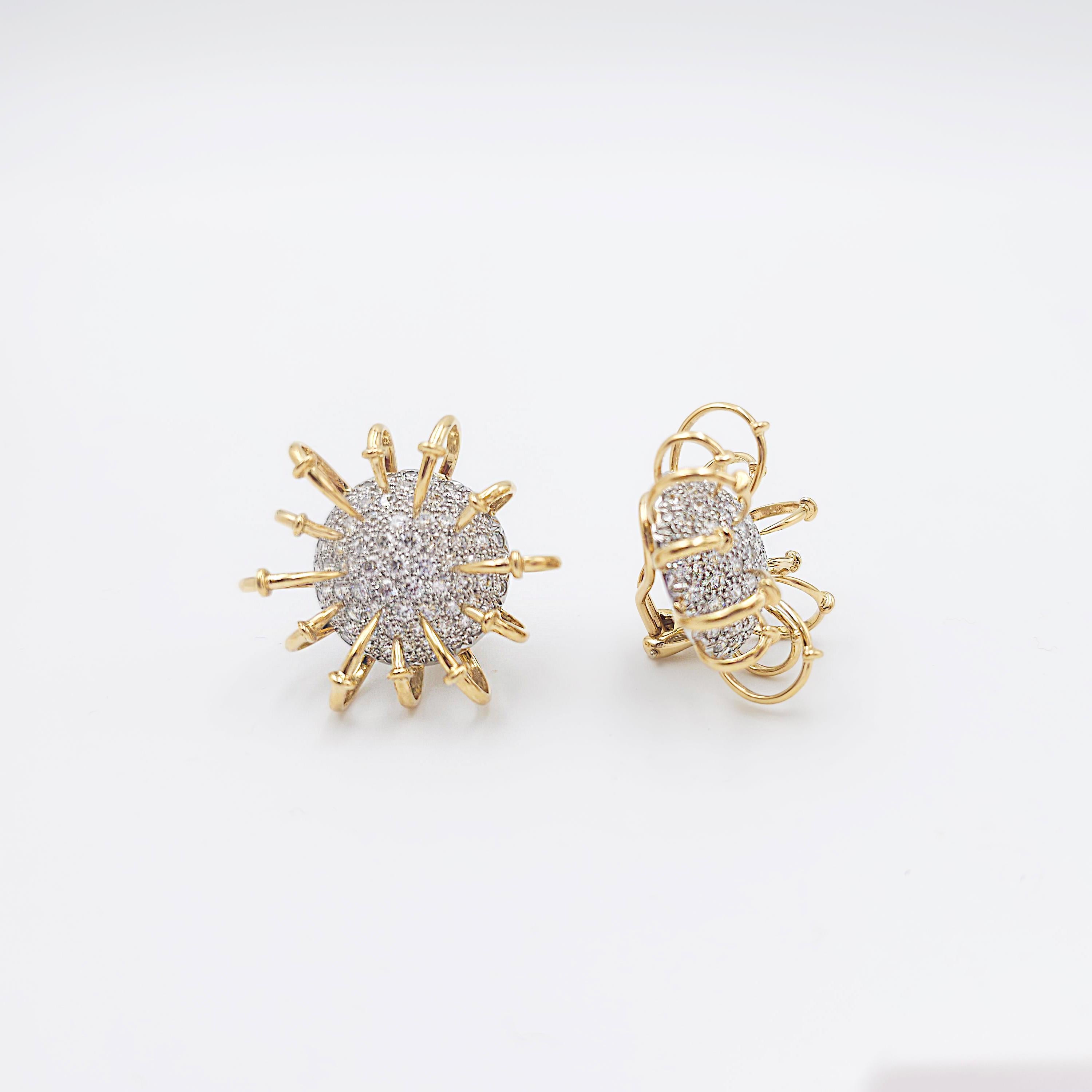 An authentic and striking pair of Jean Schlumberger for Tiffany & Co. earrings from the 'Apollo' collection. Inspired by electrons circling an atom, the circular bombé-style earrings are set with gleaming pavé diamonds (E-F, VS) weighing an