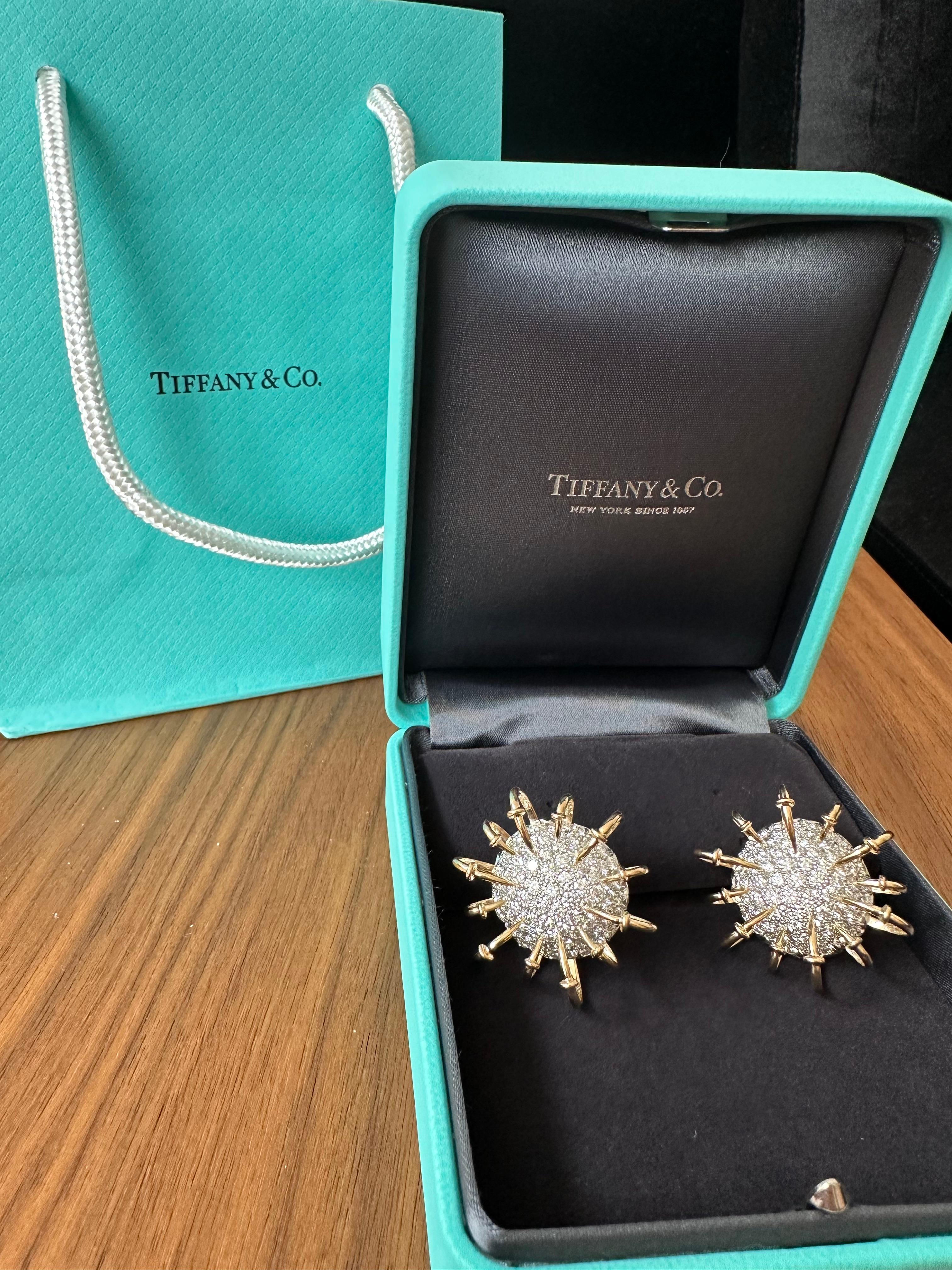 Preowned pair of Jean Schlumberger for Tiffany & Co. earrings from the 'Apollo' collection. Inspired by electrons circling an atom, the circular bombé-style earrings are set with gleaming pavé diamonds (E-F, VS) weighing an estimated 5.69 carats