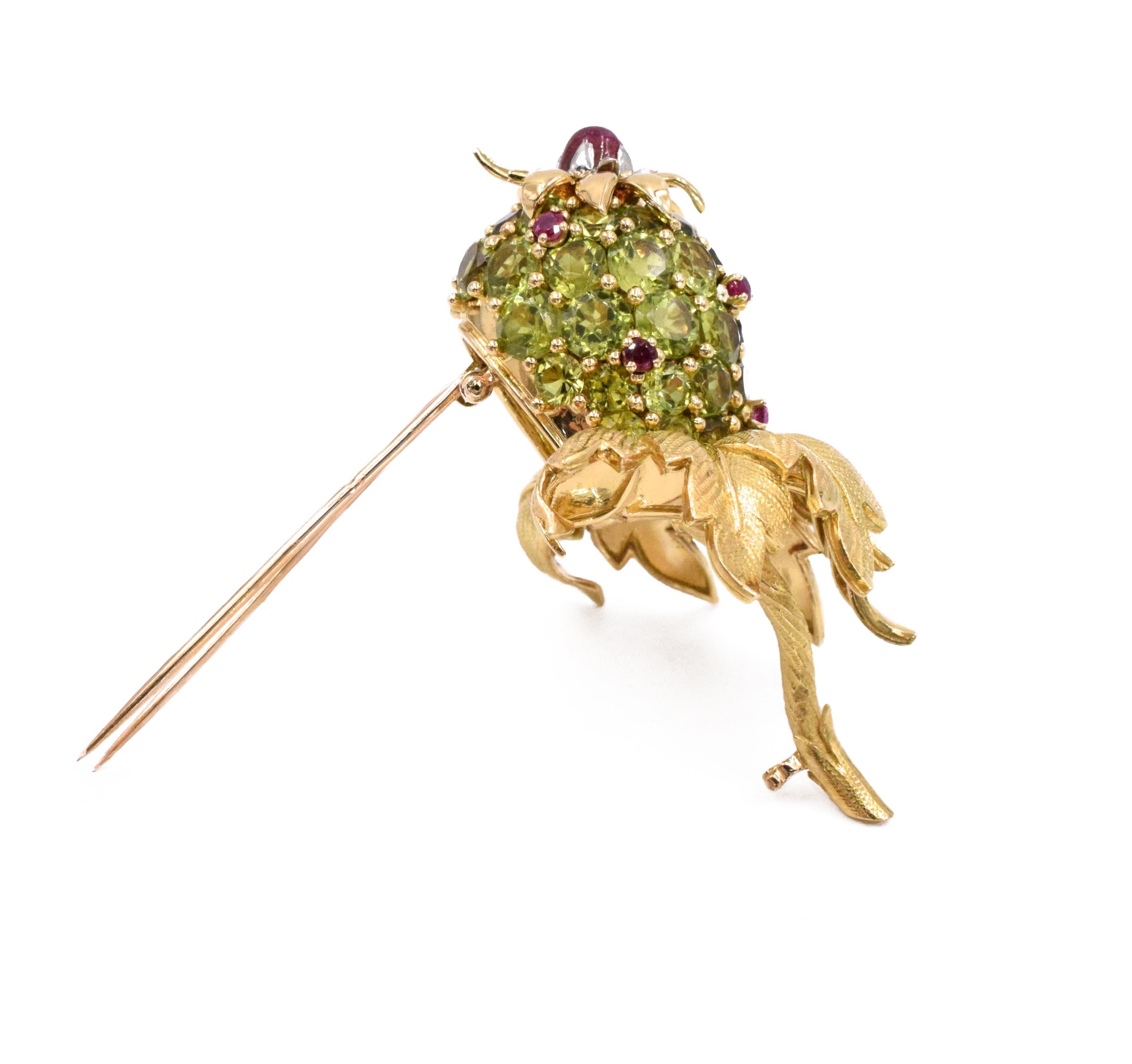 J. Schlumberger  'Pineapple' Peridot, Ruby, and 18k Yellow Gold Pin. This pin has round peridots (approximately 20- 22ct) and cabochon and round rubies (approximately 0.7- 08ct) all set in 18k yellow gold. Signed Schlumberger Paris, makers mark, and