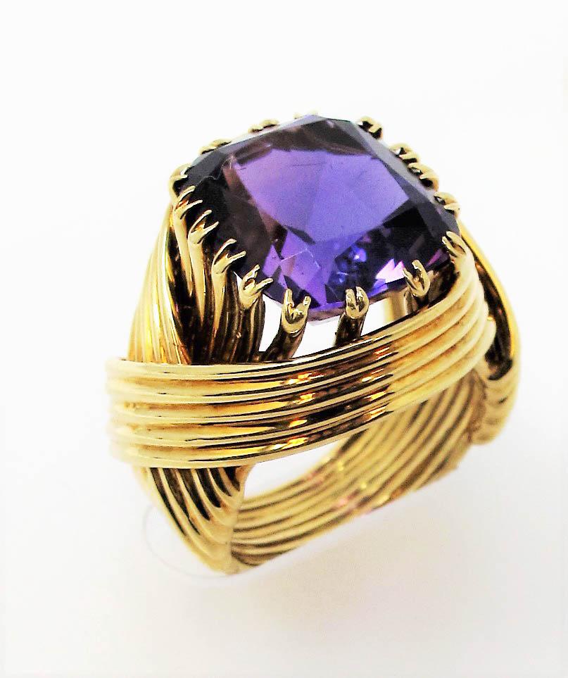 Incredible limited edition amethyst cocktail ring designed by Jean Schlumberger for Tiffany & Co. This stunning statement piece features a large cushion mixed cut amethyst stone in a beautifully saturated purple color. The gorgeous purple stone is