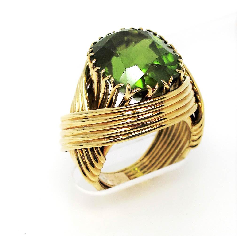 Incredible limited edition peridot cocktail ring designed by Jean Schlumberger for Tiffany & Co. This stunning statement piece features a large cushion mixed cut peridot stone in a beautifully saturated lime green color. The gorgeous green stone is